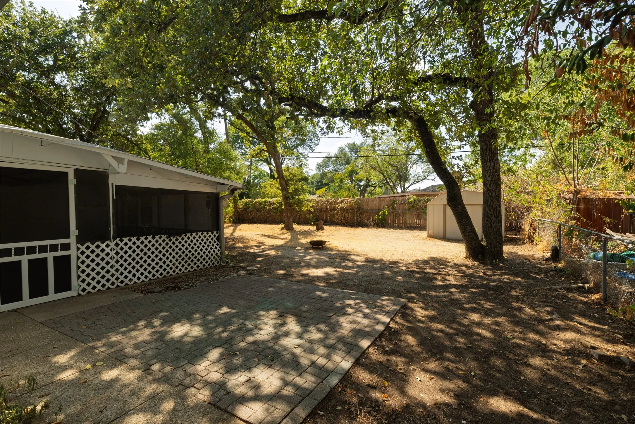 Mature trees provide shade to large  screened in back patio