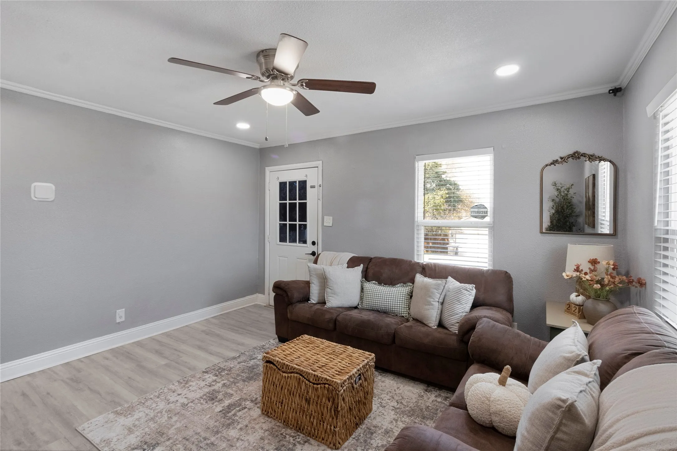 Light gray walls, wood-finish flooring, recessed lighting, ceiling fan, and white trim throughout