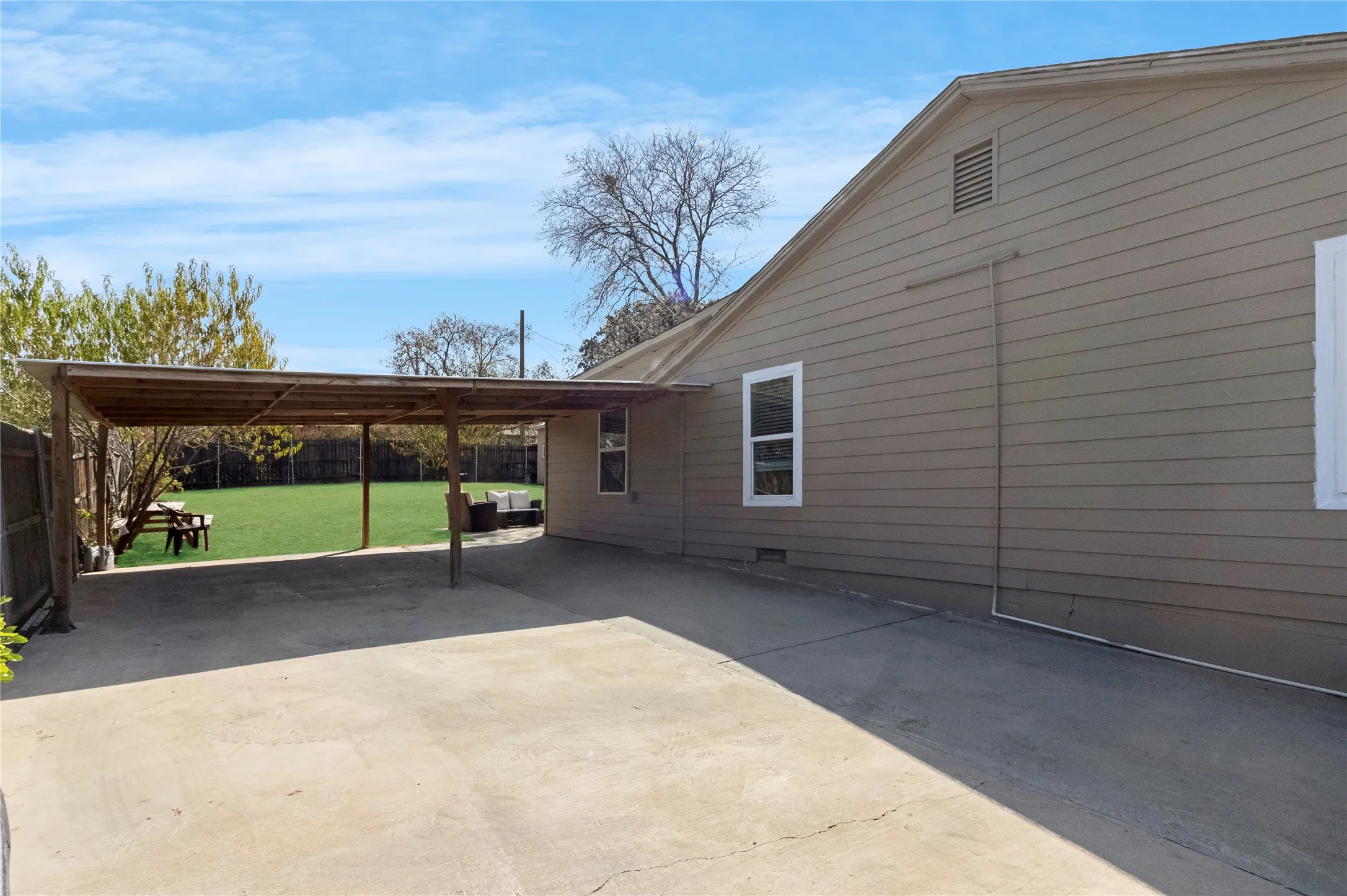 Covered carport structure with concrete driveway