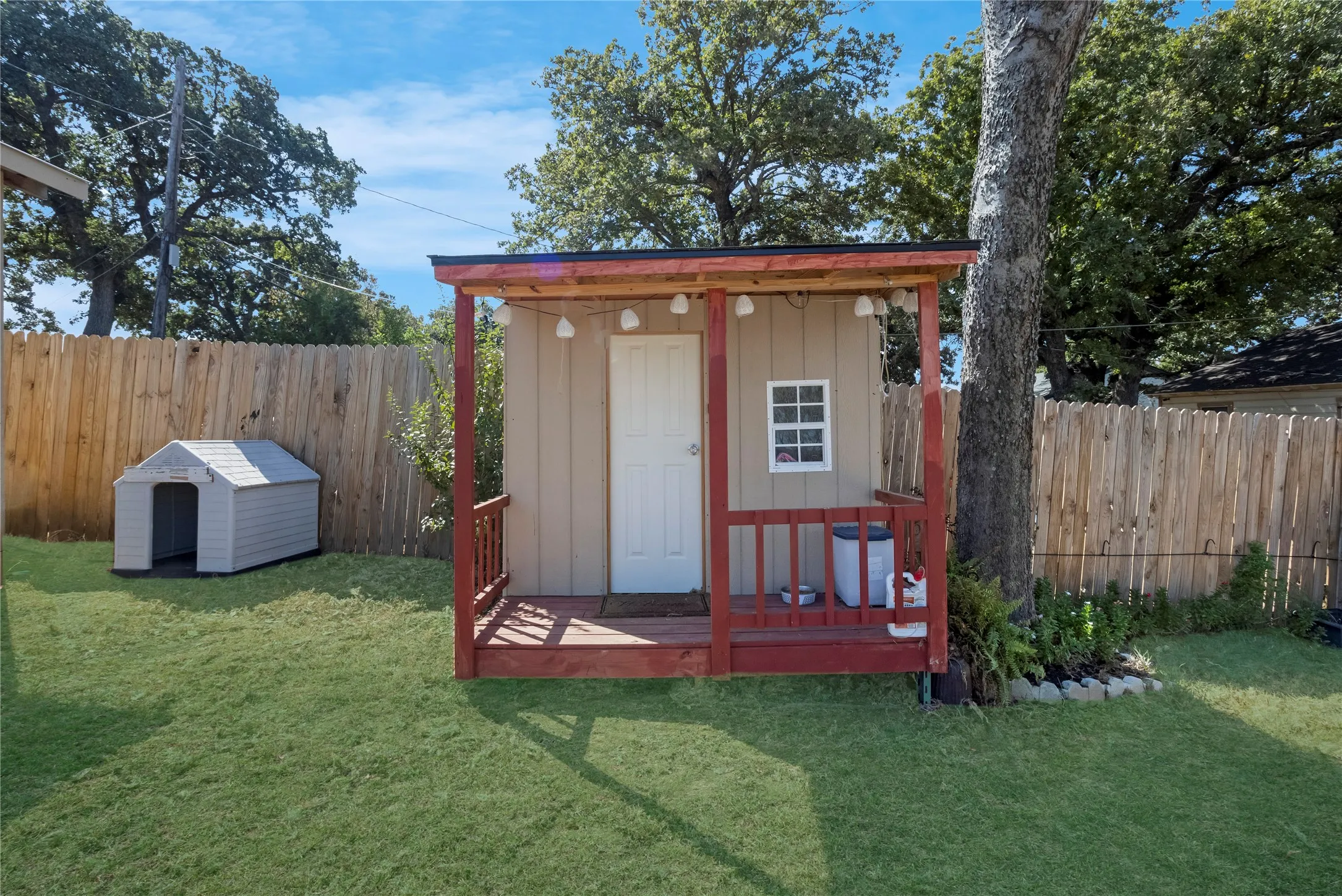 Detached shed with an integrated porch, featuring a white door and a multi-pane window