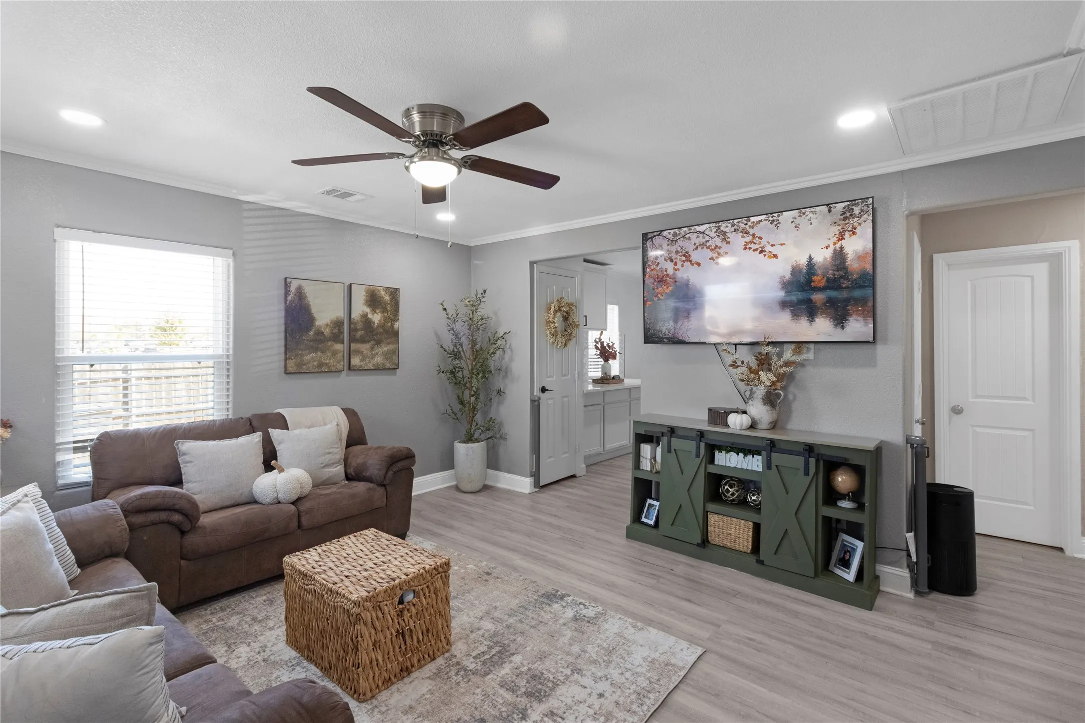 Recessed lighting, ceiling fan, crown molding, wood-finish flooring, and a window with blinds