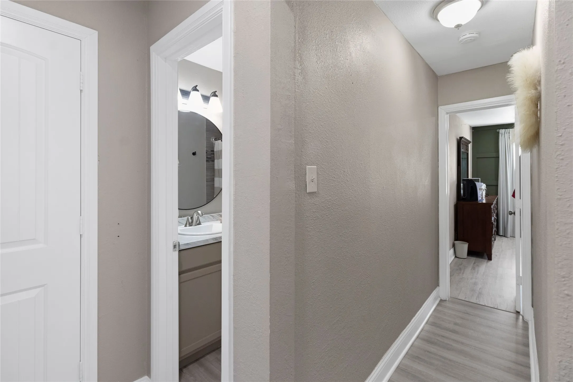 Hallway with light gray walls and wood-finish flooring