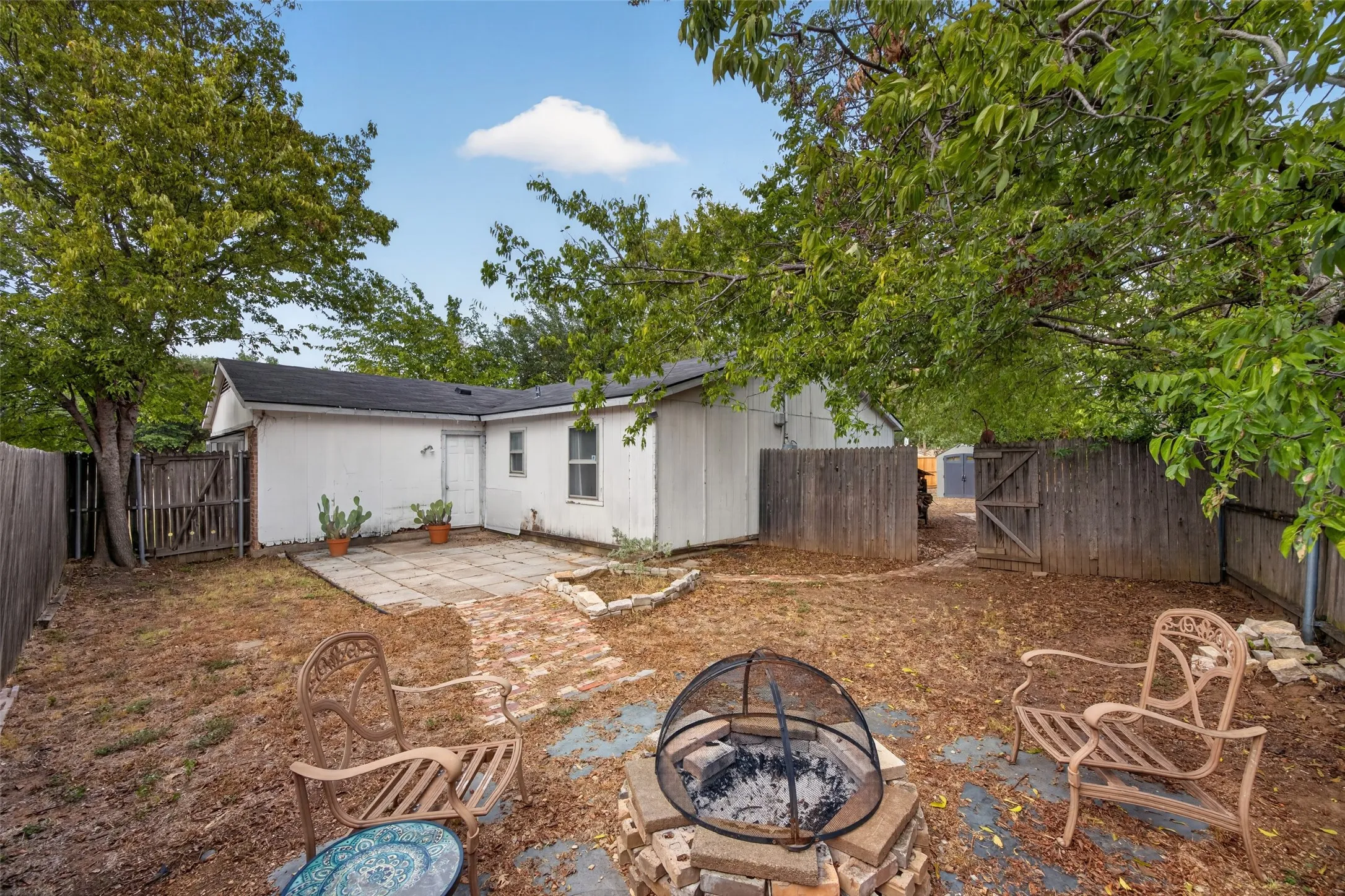 Large patio plus a firepit with a gate to the rest of the backyard