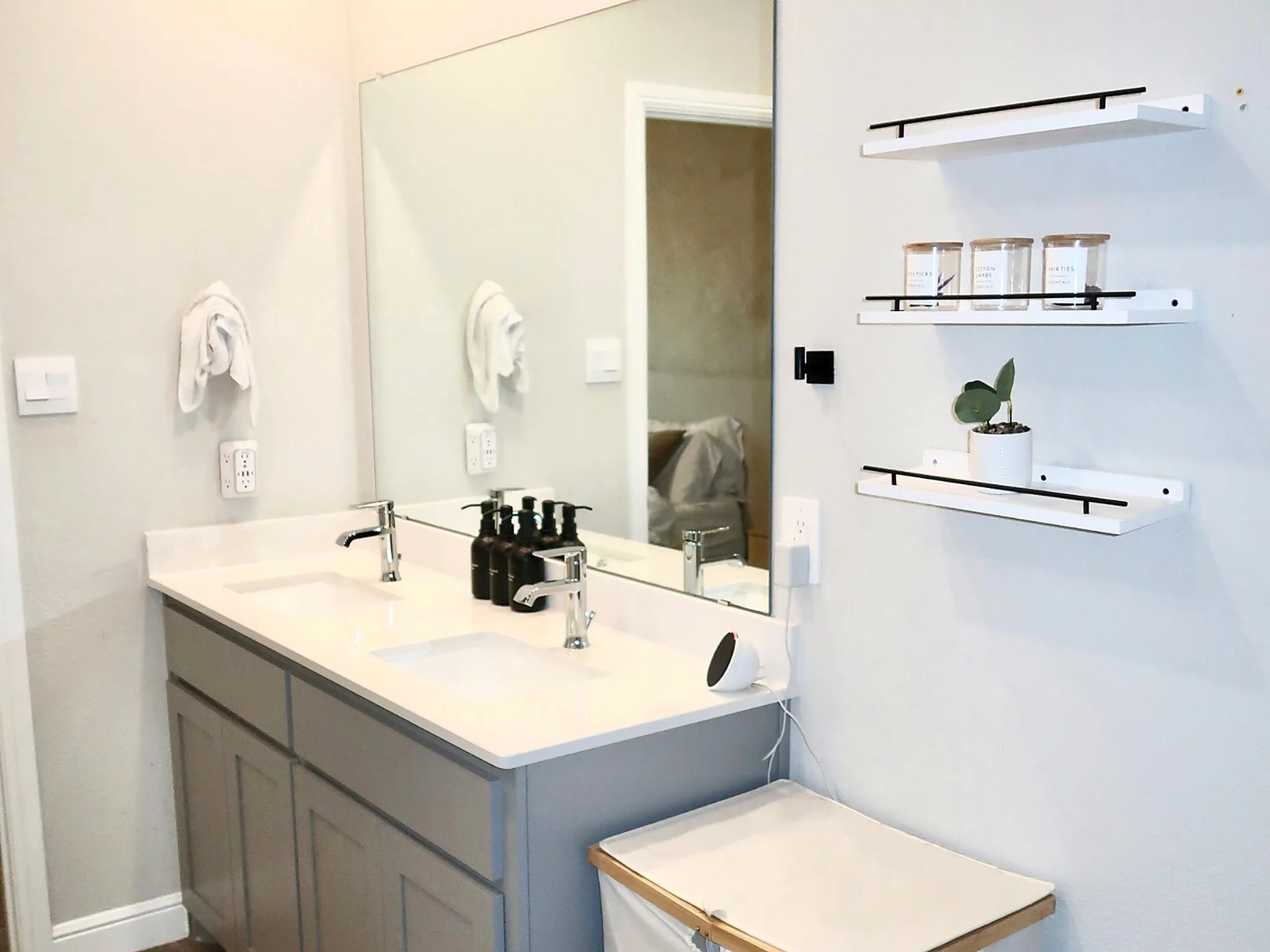 Dual undermount sinks with chrome faucets, a light-toned countertop, and a vanity with paneled cabinetry