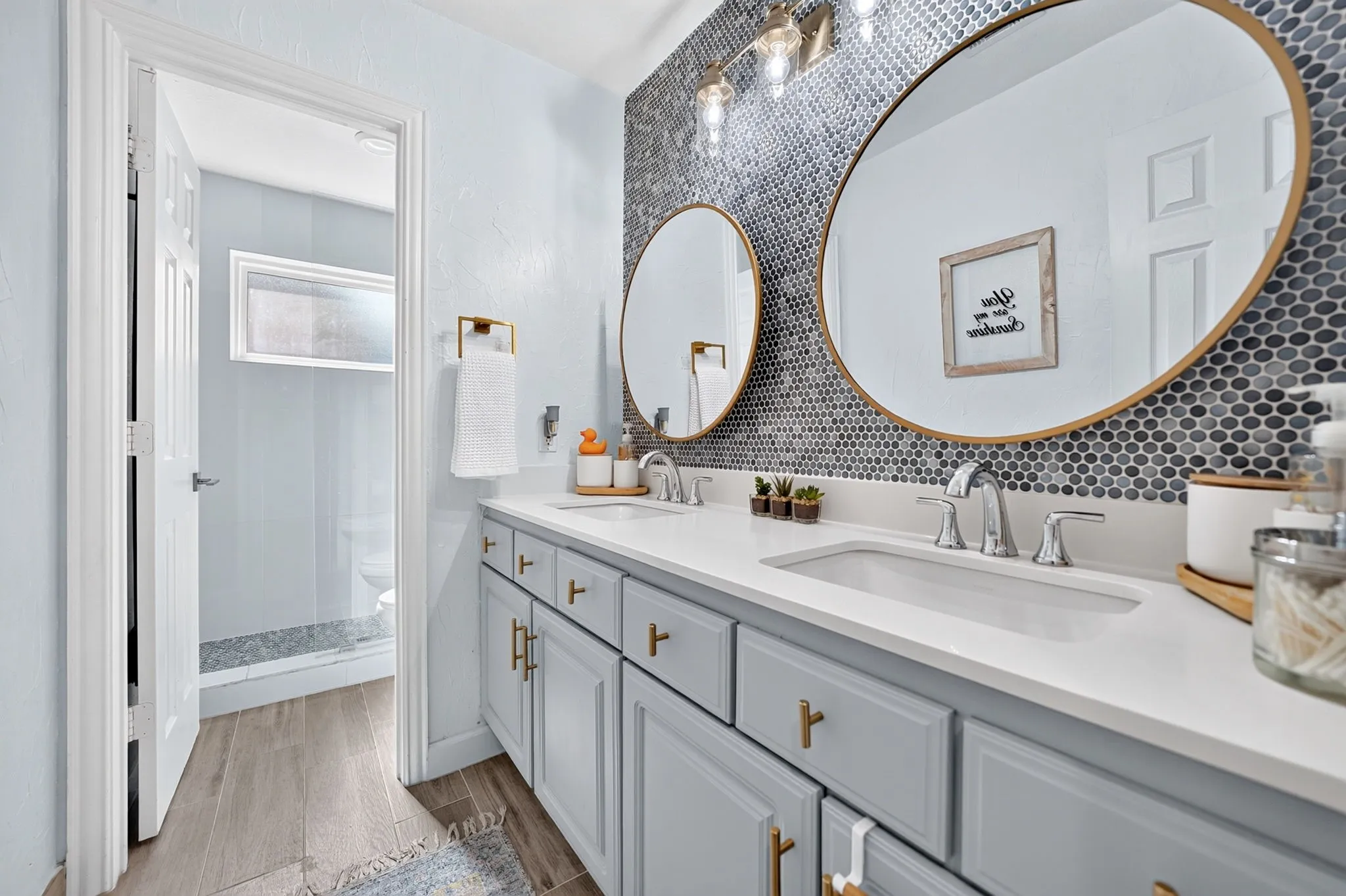 Dual vanity with white undermount sinks, chrome fixtures, and light gray cabinetry