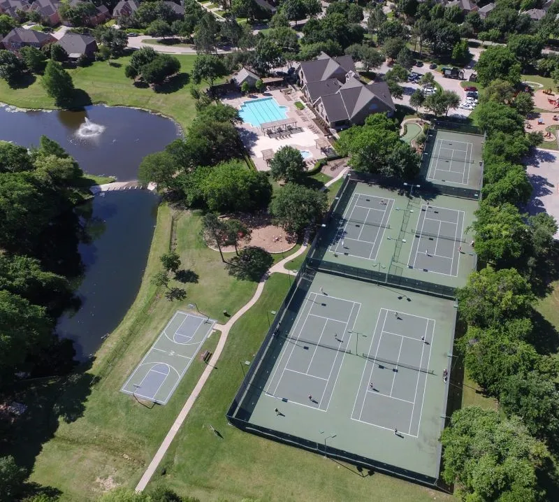 Community amenities featuring a swimming pool, multiple tennis courts, a basketball court, a pond with a fountain, and a clubhouse building