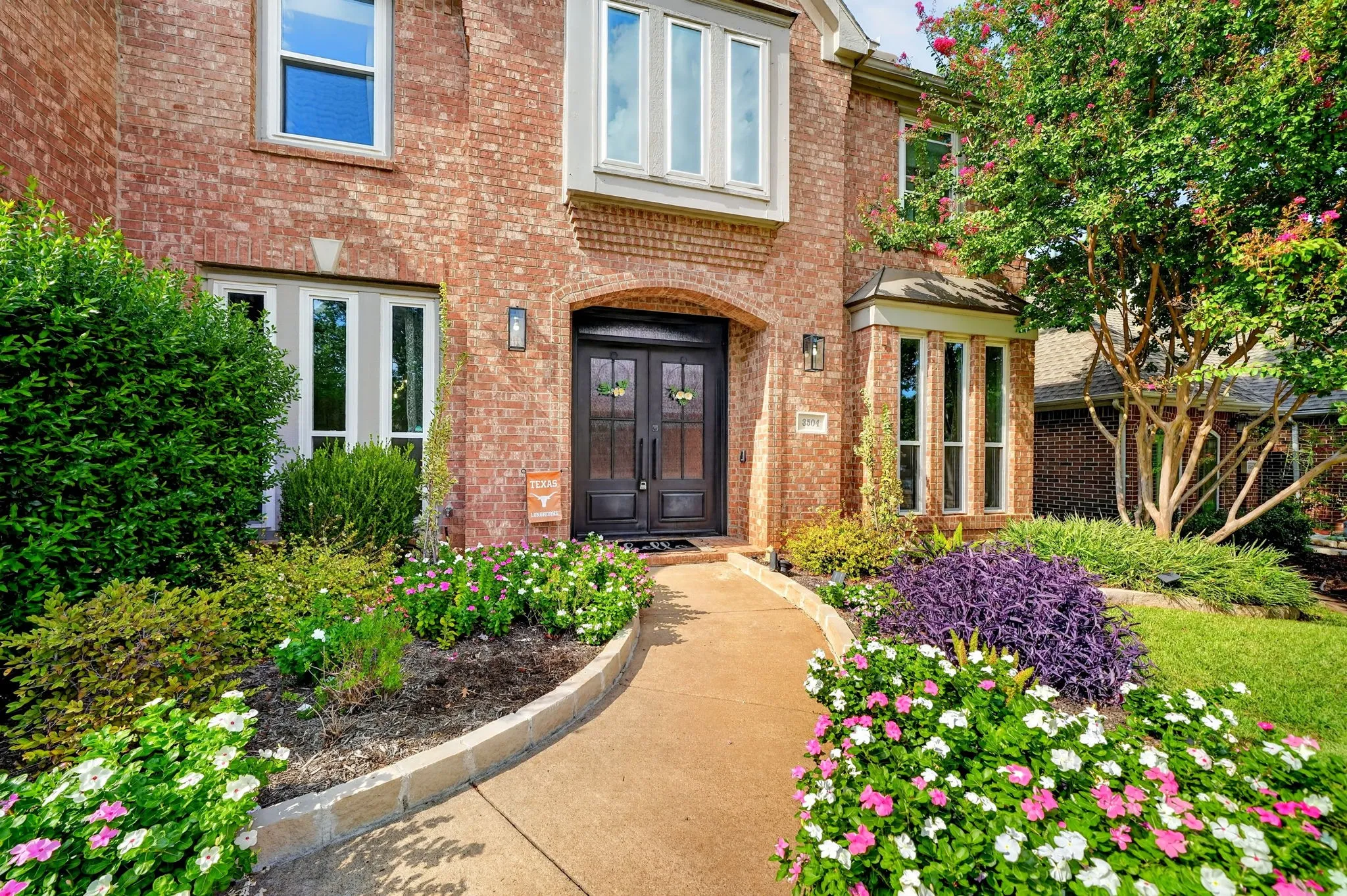 Brick exterior with bay windows and a double entry door