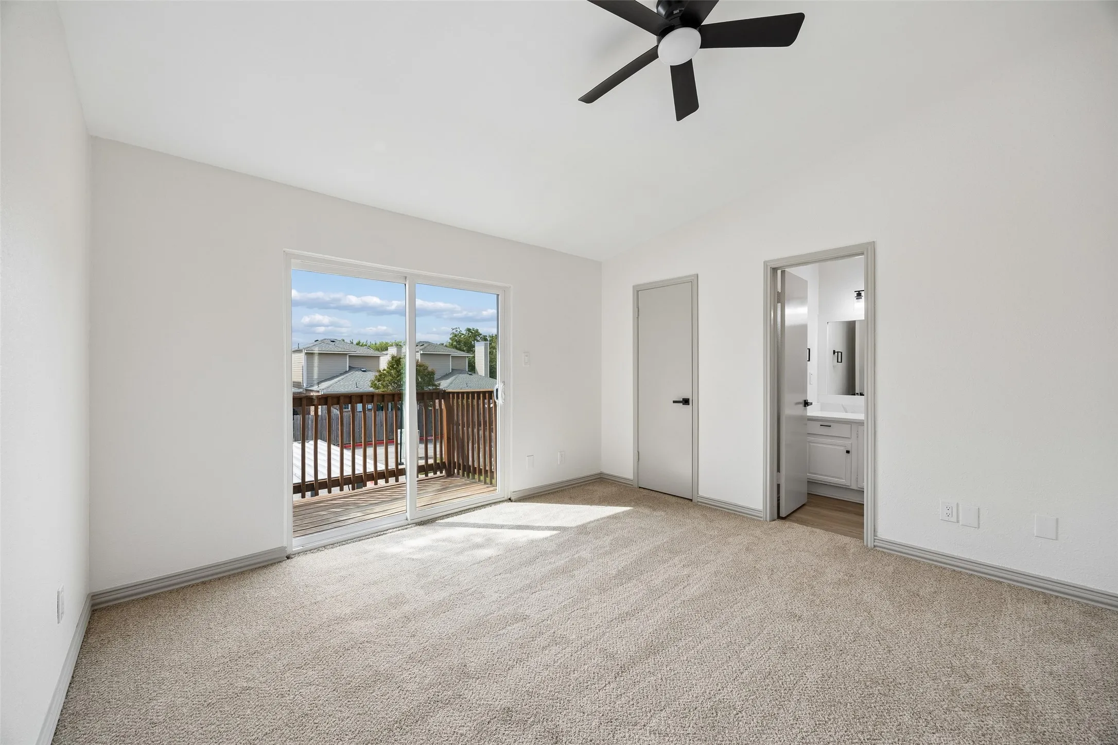 Sliding glass door opening to a private wood-railed balcony