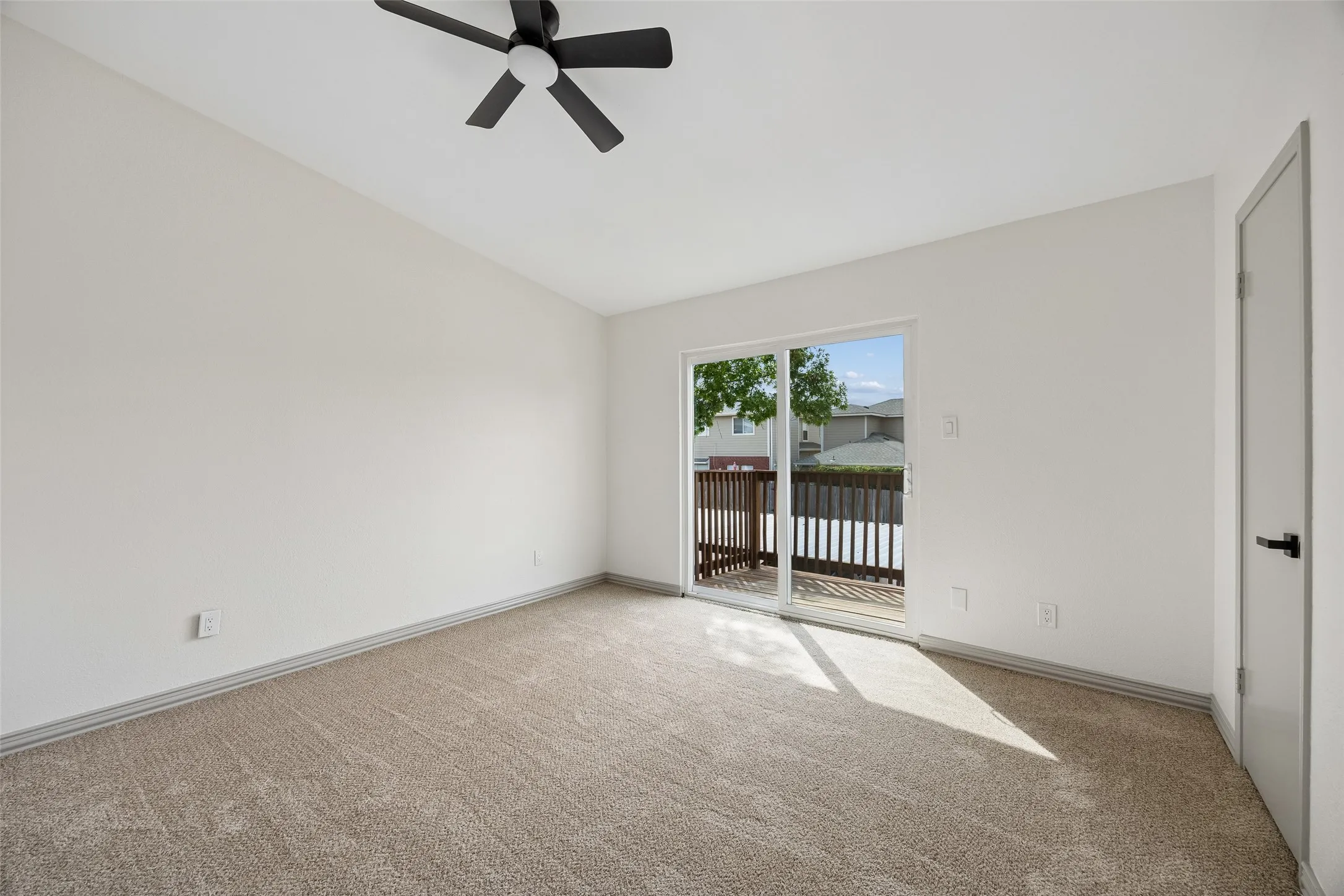 Neutral tone carpeting and a ceiling fan with integrated lighting