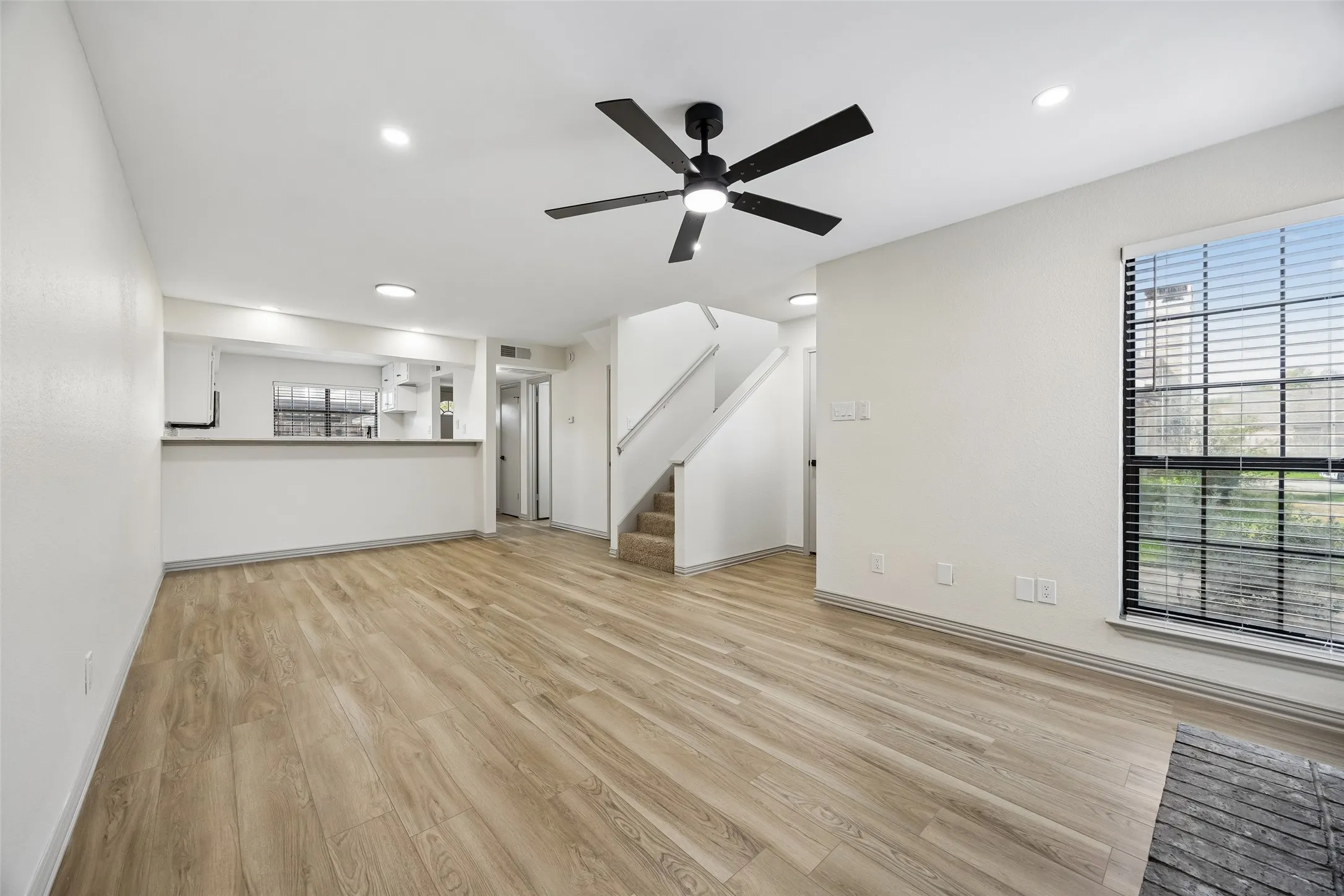Wood-finish flooring, recessed lighting, and a modern ceiling fan