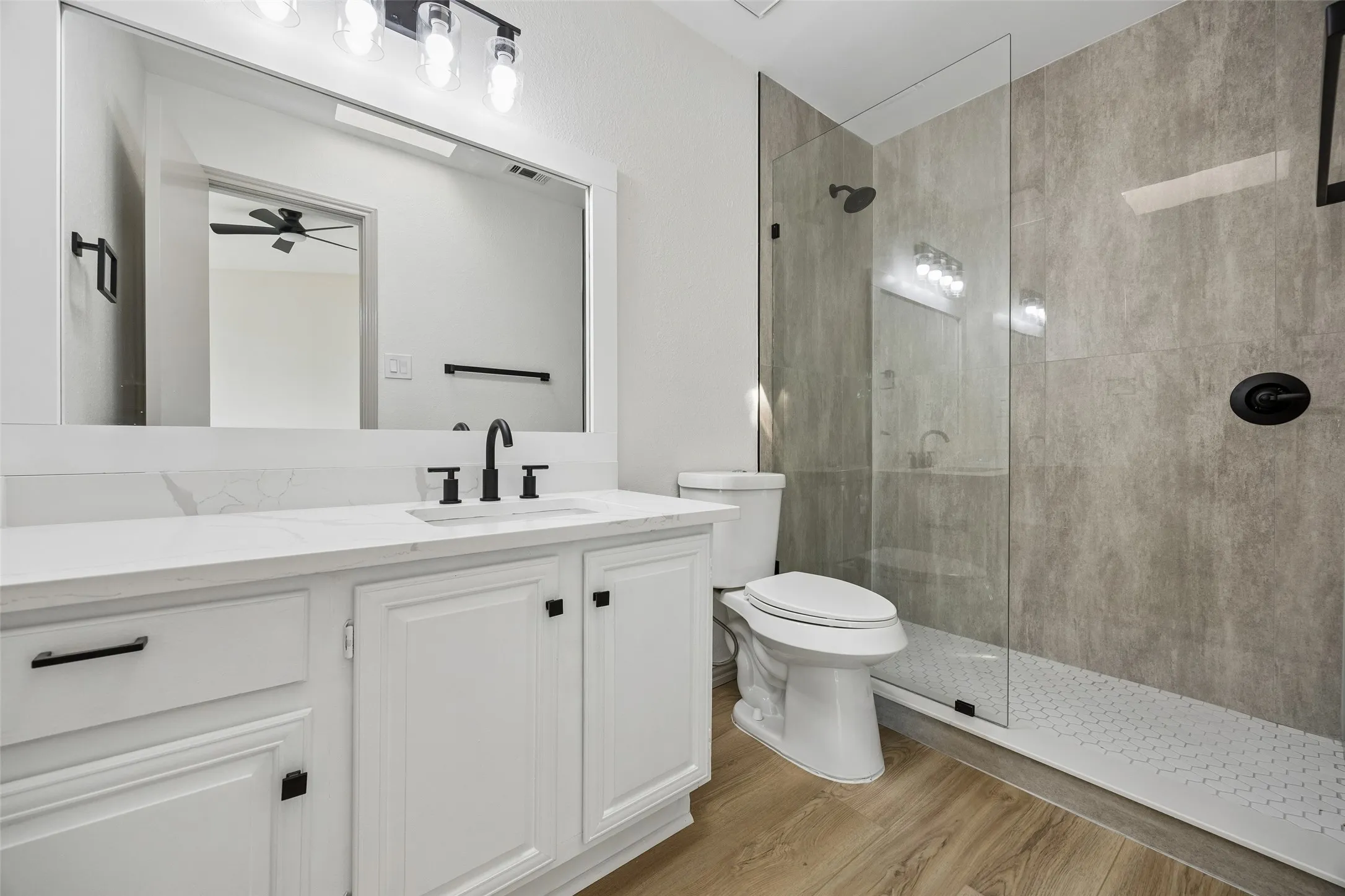 Vanity with white cabinetry, integrated sink, and black fixtures