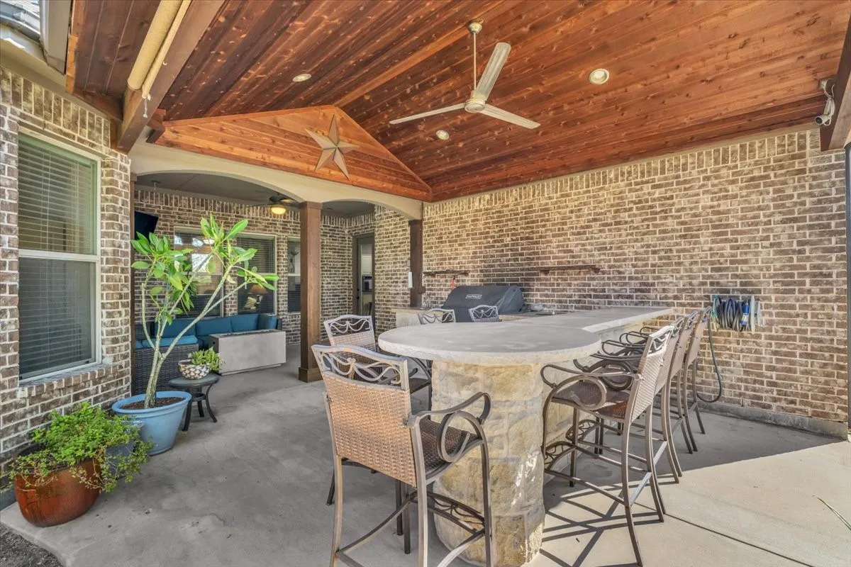Covered patio with a wood-plank ceiling, ceiling fan, and recessed lighting