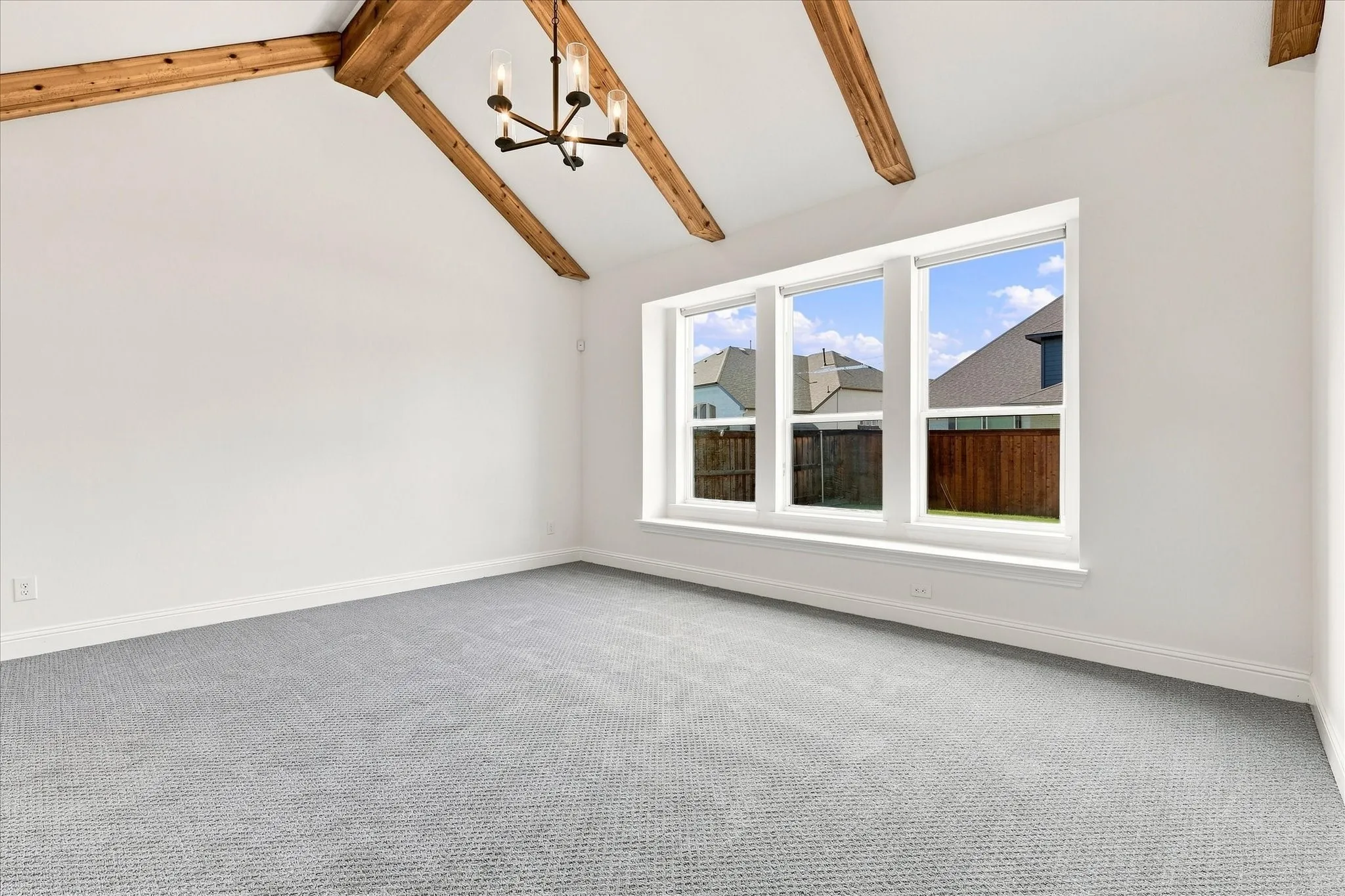Your primary bedroom with vaulted ceilings, wood beams adding warmth