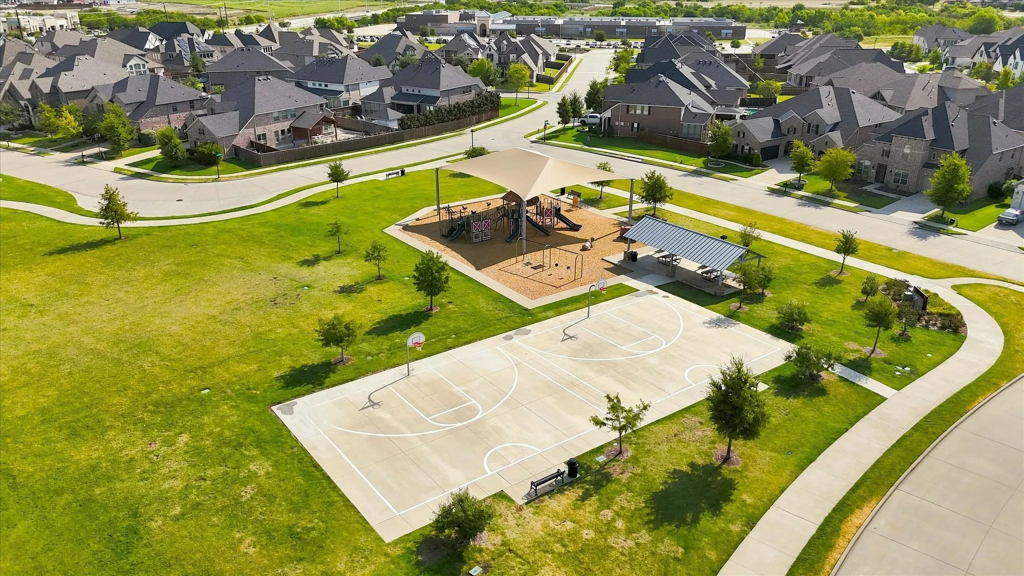 Neighborhood park with a shaded play structure, covered picnic area, and a basketball court