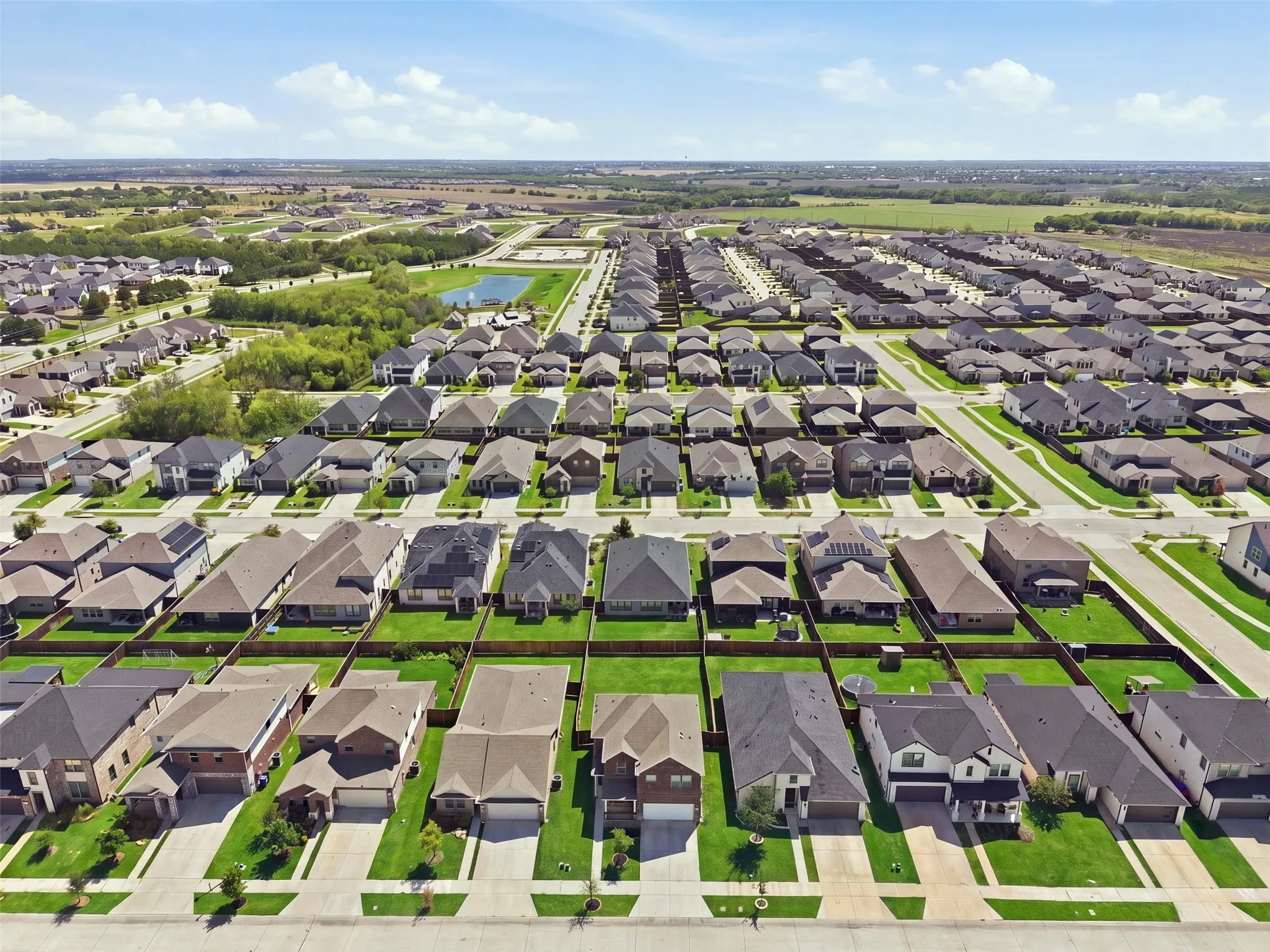 Residential neighborhood with uniform lot sizes and individual homes, featuring paved streets and established green lawns