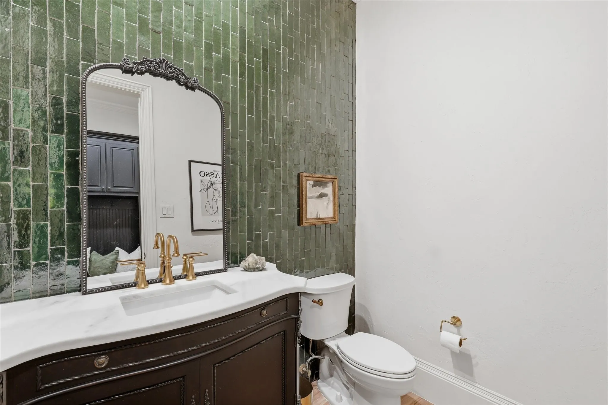 A dramatic zellige-tile wall and gorgeous vanity bring character to this beautifully updated powder bath.