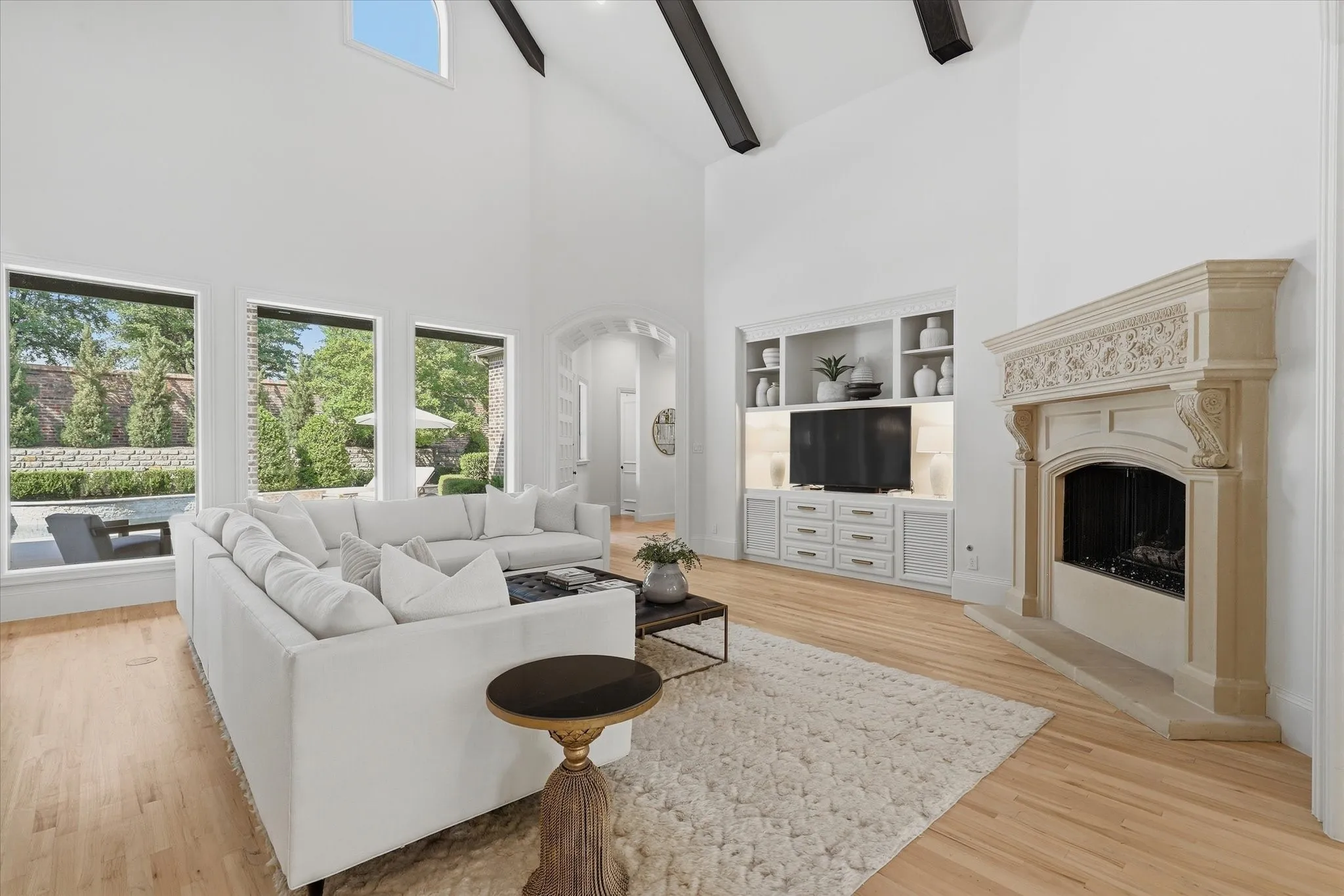 Vaulted and beamed ceilings, refined built-ins and wall of windows define the light-filled family room.