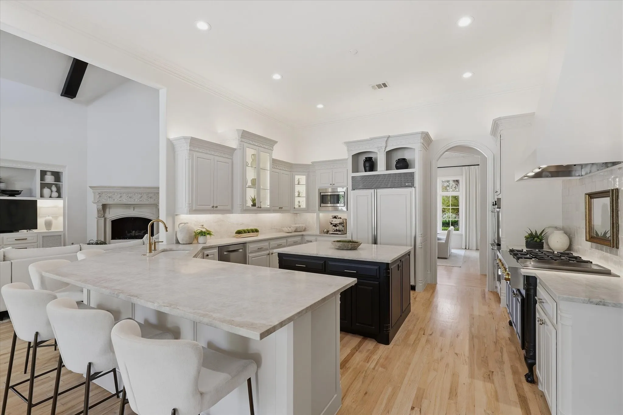 A sweeping kitchen view highlights Sub-Zero refrigeration, double ovens and abundant cabinetry and workspace.