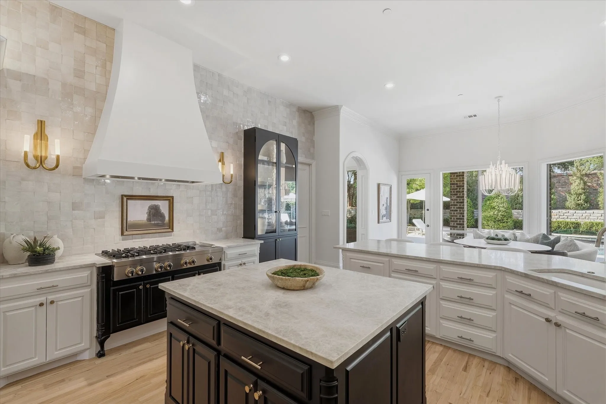 The JennAir six-burner gas cooktop with griddle is framed by a full wall of handcrafted zellige tile, designer sconces and a custom hood.