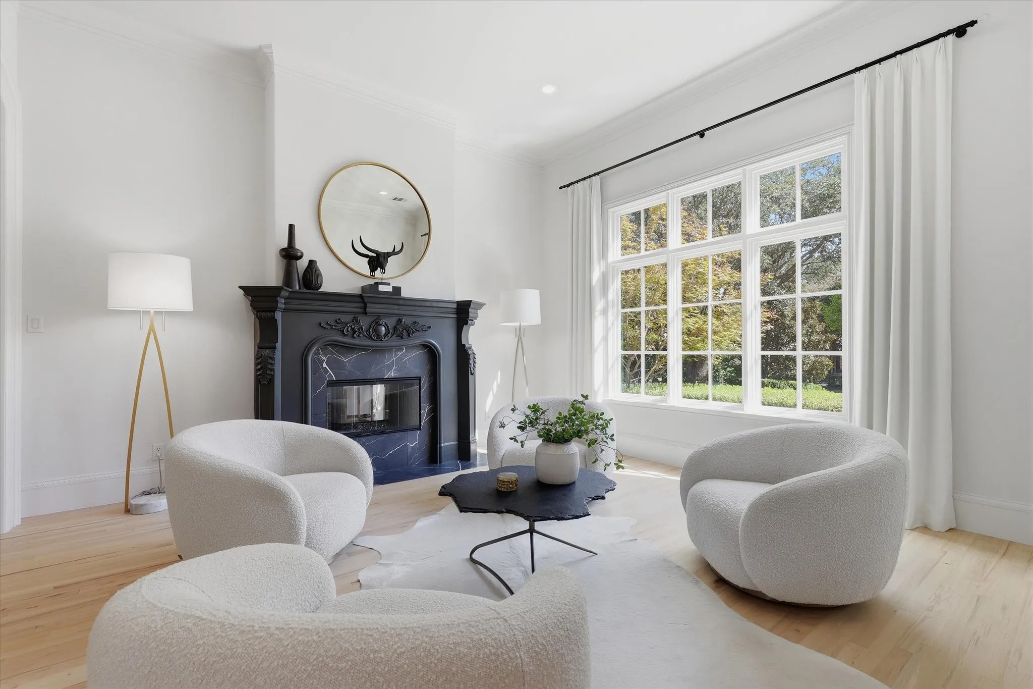 An intimate formal living room pairs garden views with a richly detailed fireplace.