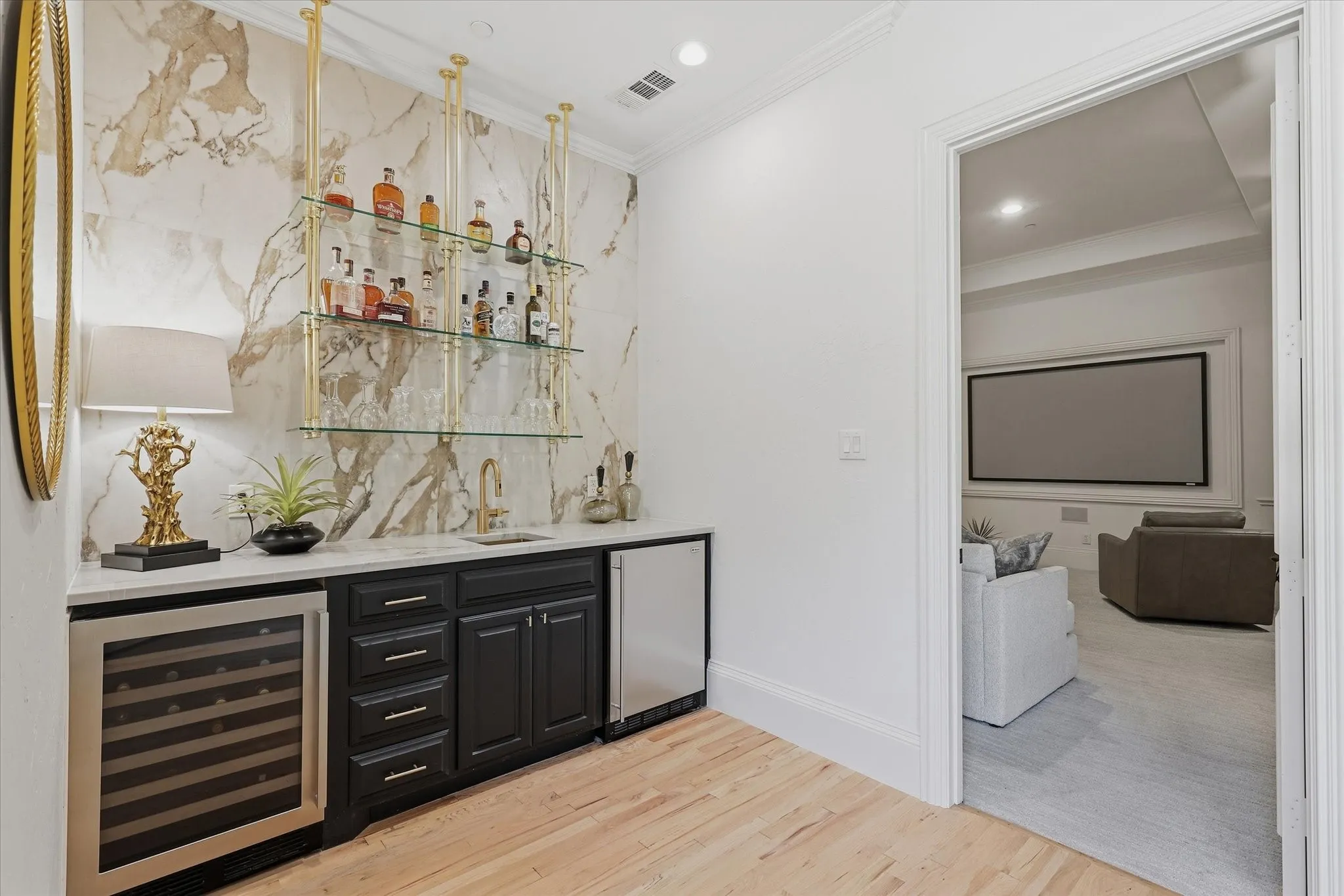 The reimagined bar features dramatic stone, display shelving and wine refrigeration just outside the media room.