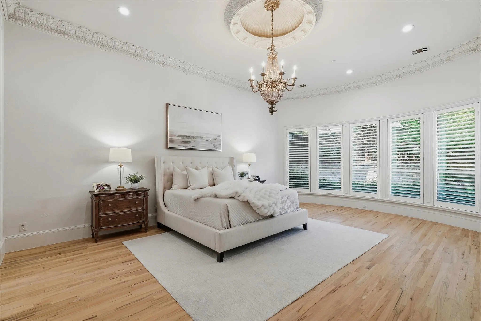 A wall of windows fills the generously scaled primary suite with natural light and beautiful pool views.