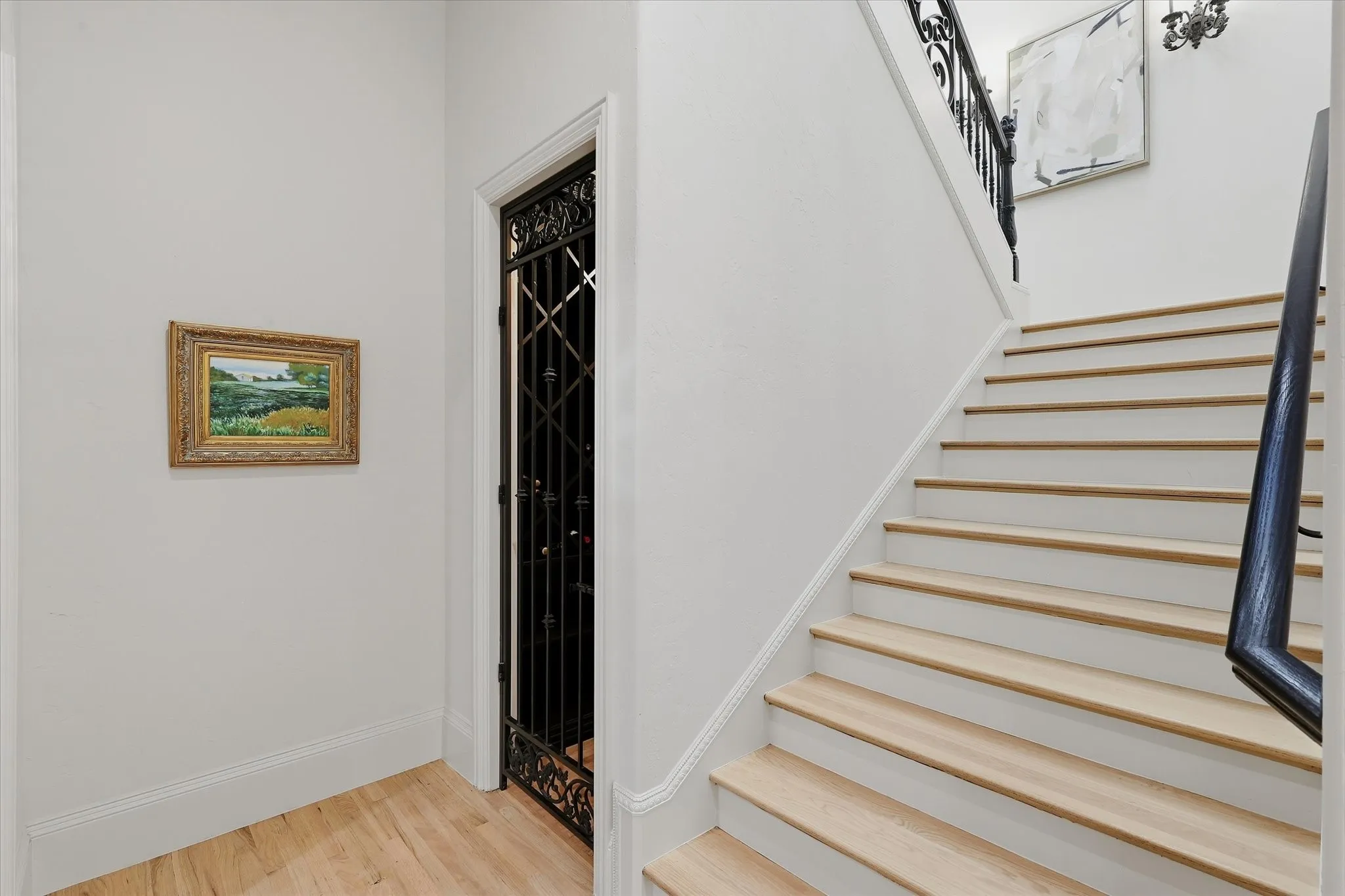The dedicated wine cellar is discreetly tucked beneath the staircase behind an ornamental iron door.