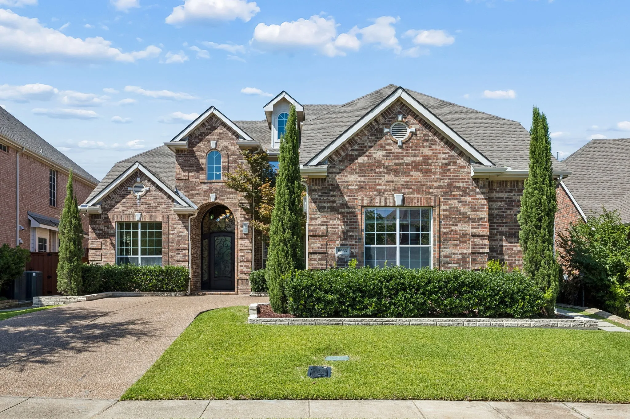 Beautiful drive-up appeal welcomes you to this impressive residence, featuring a stately arched entry, custom iron front door, distinctive rooflines, mature evergreens and manicured landscaping.