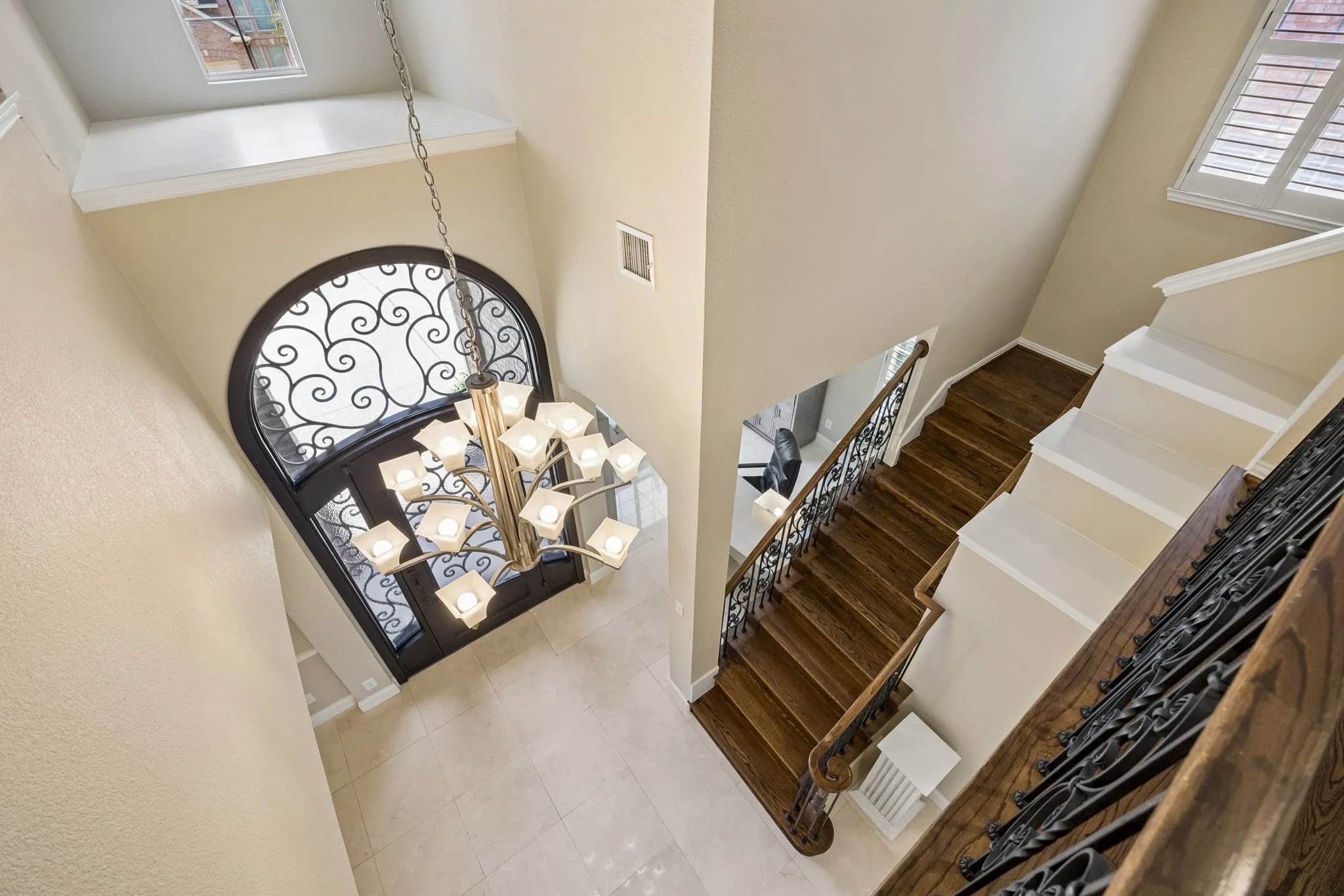 Beautiful solid hardwood staircase with wrought iron balusters add character as they lead to additional bedrooms, living area, wet bar and media room.