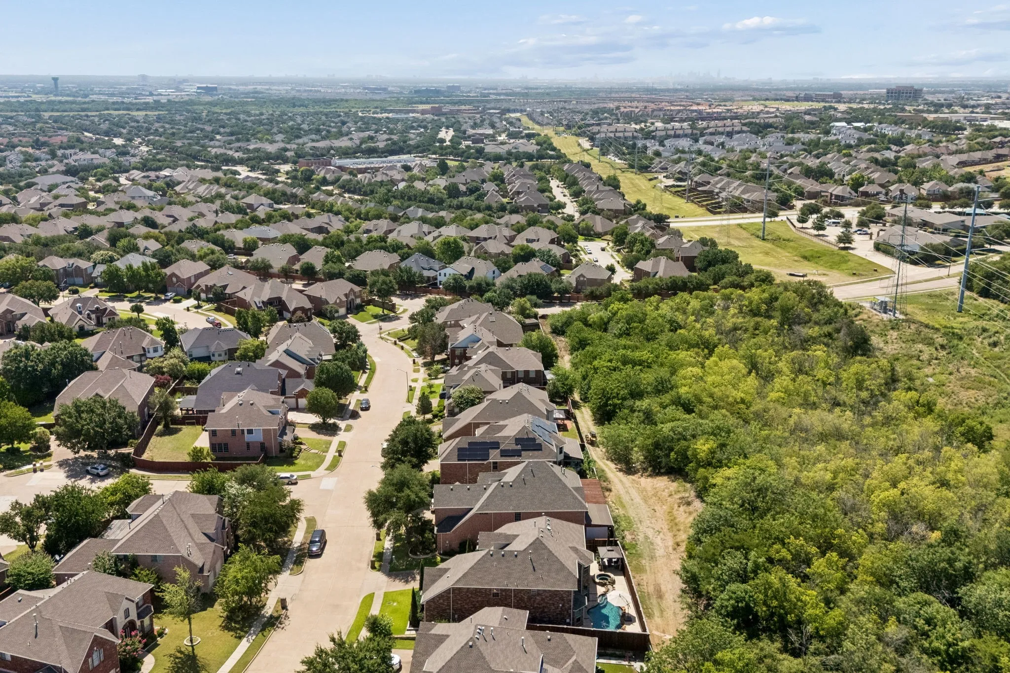 Rear aerial view highlights the home’s exceptional position along a lush Greenbelt, offering added privacy, mature tree views and no immediate rear neighbors.