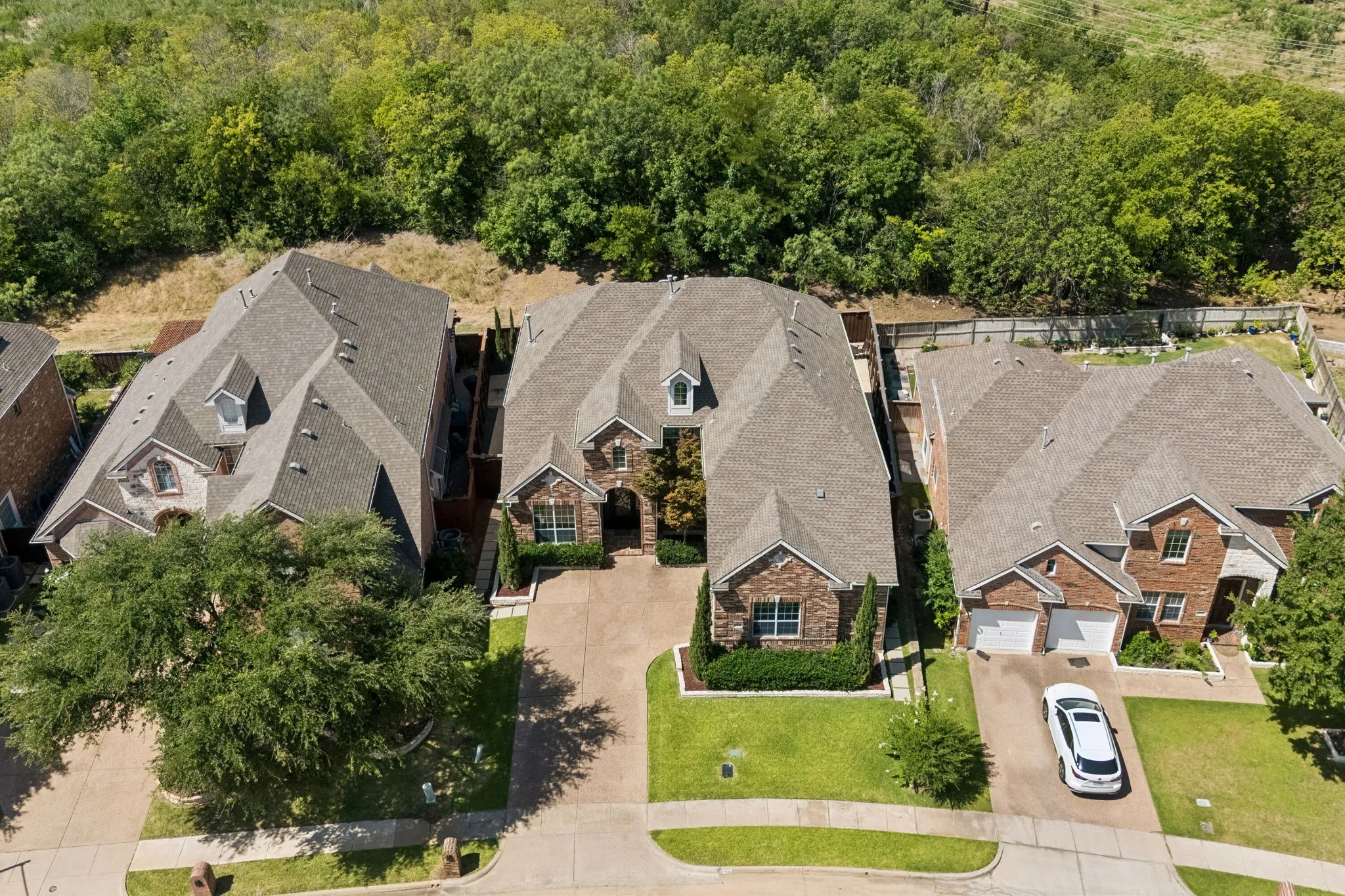 Front aerial view highlights a beautifully maintained, thoughtfully detailed home with manicured landscaping, a clean exterior presentation and impressive curb appeal.