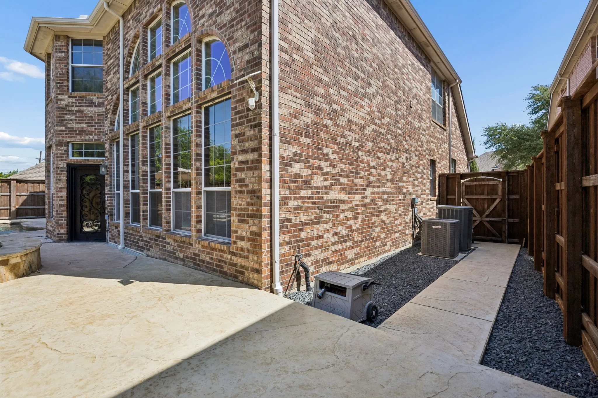 Thoughtfully finished side yard with clean hardscape and gravel accents, reflecting the same attention to detail found throughout the property.