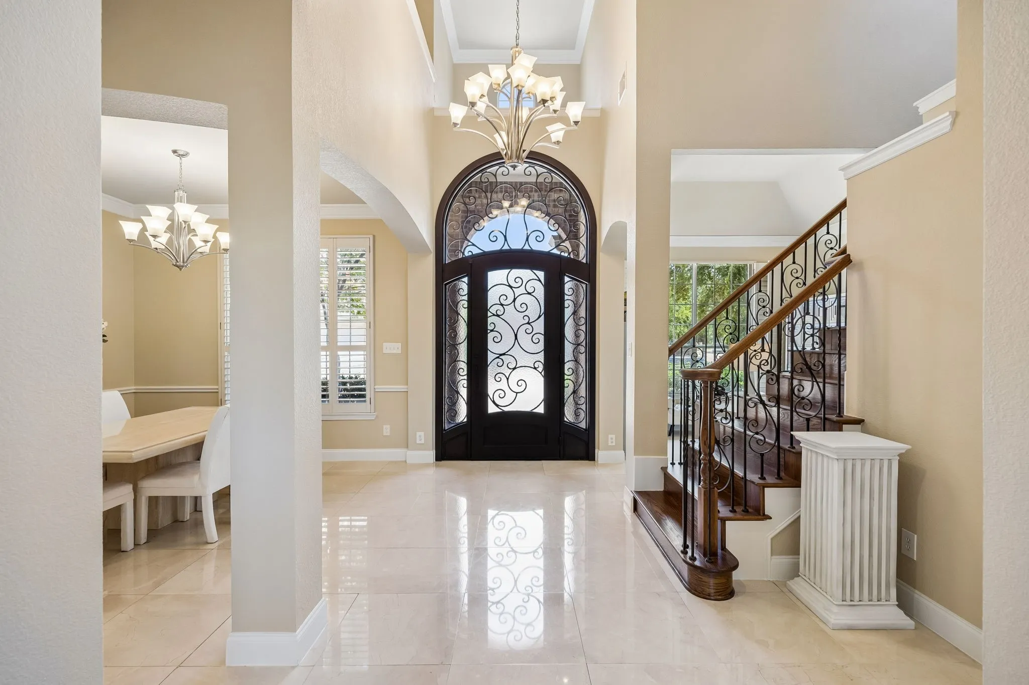 This dramatic two-story entry leaves you with a memorable first impression, featuring natural stone floors and a stunning custom iron and glass front door that sets an elegant tone.