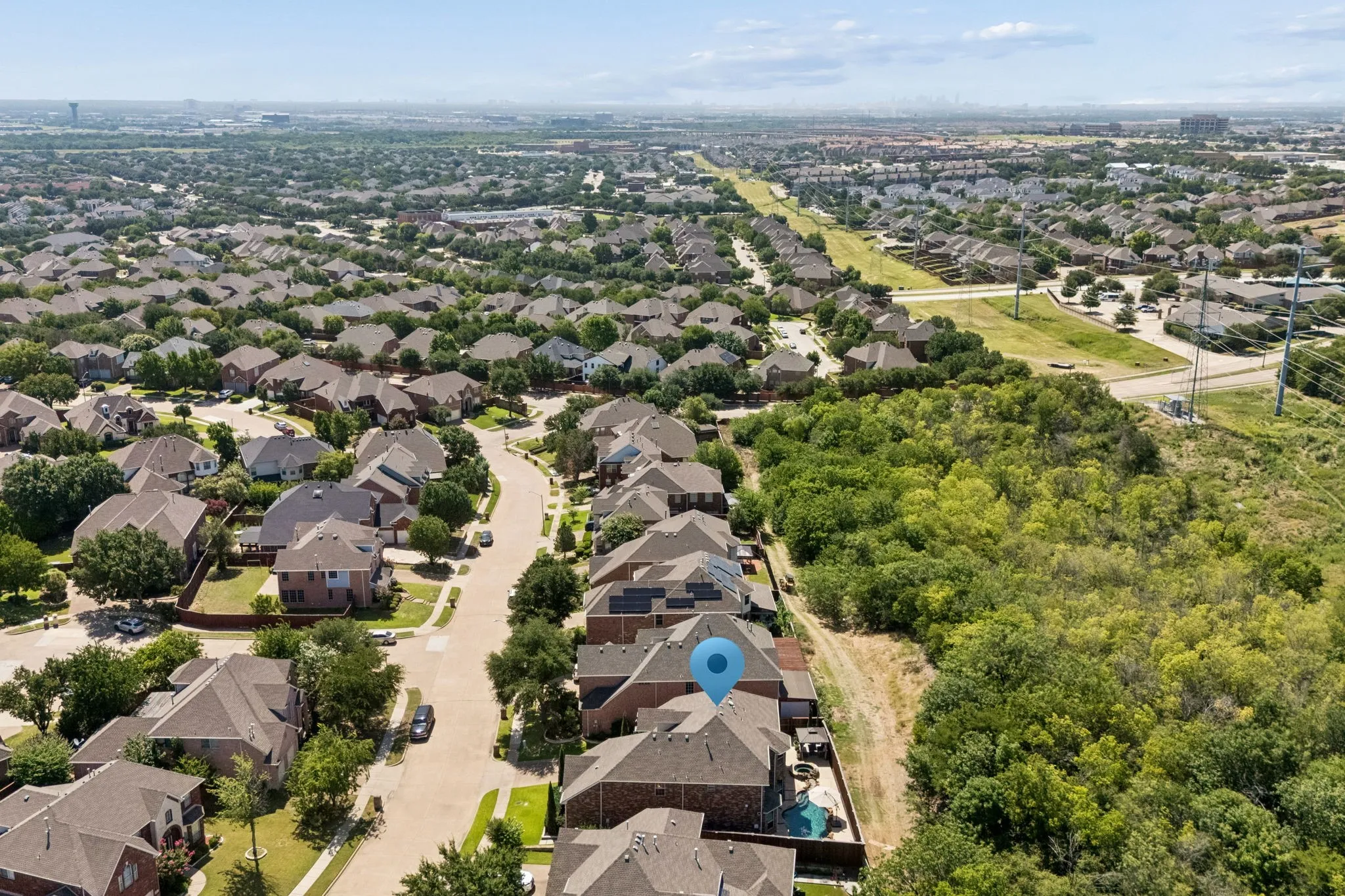 Aerial view pinpoints the home’s location within the neighborhood, highlighting its desirable position along the greenbelt with mature trees, added privacy and no immediate rear neighbors.