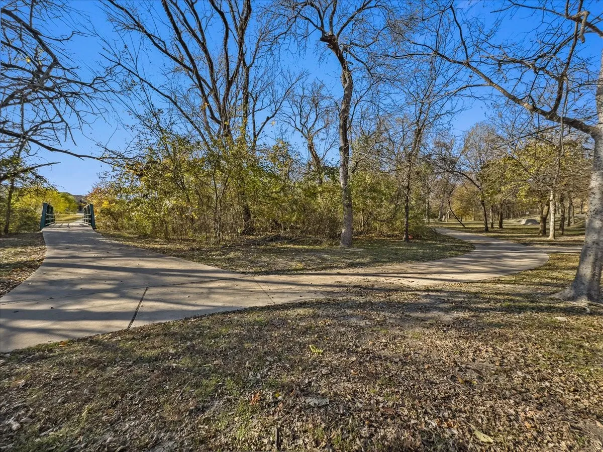 Paved walking paths surrounded by mature trees and natural landscaping