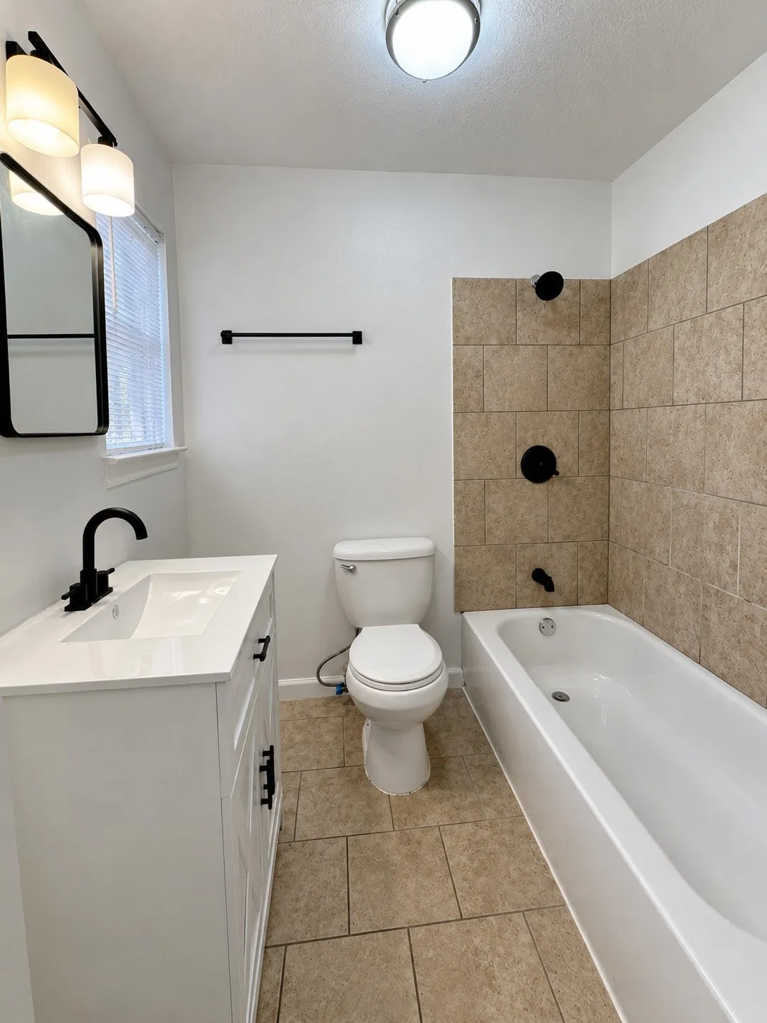 White vanity with an integrated sink, matte black faucet, and hardware