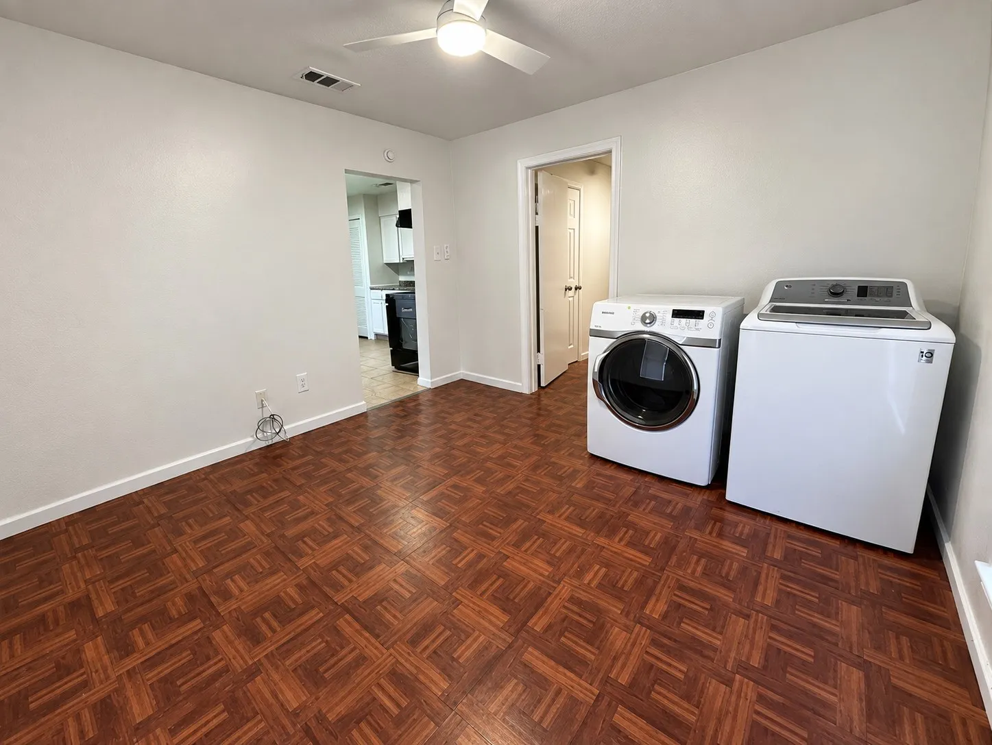 Wood-finish flooring, ceiling fan, and white appliances