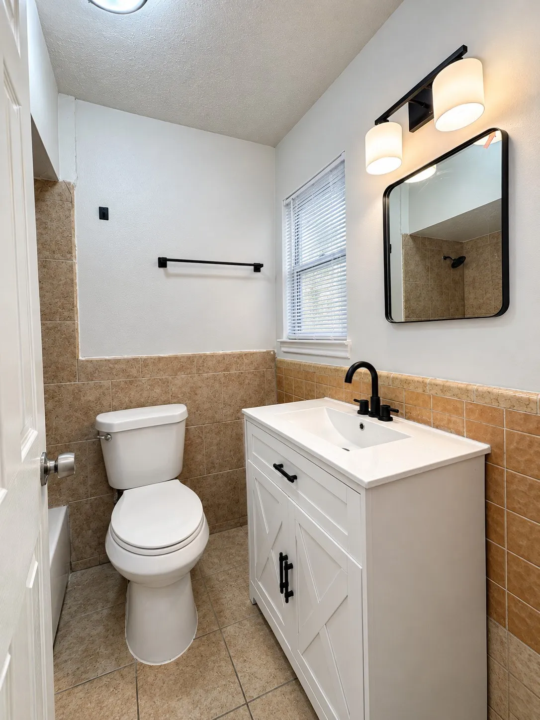 White vanity with black hardware, integrated sink, and matte black faucet