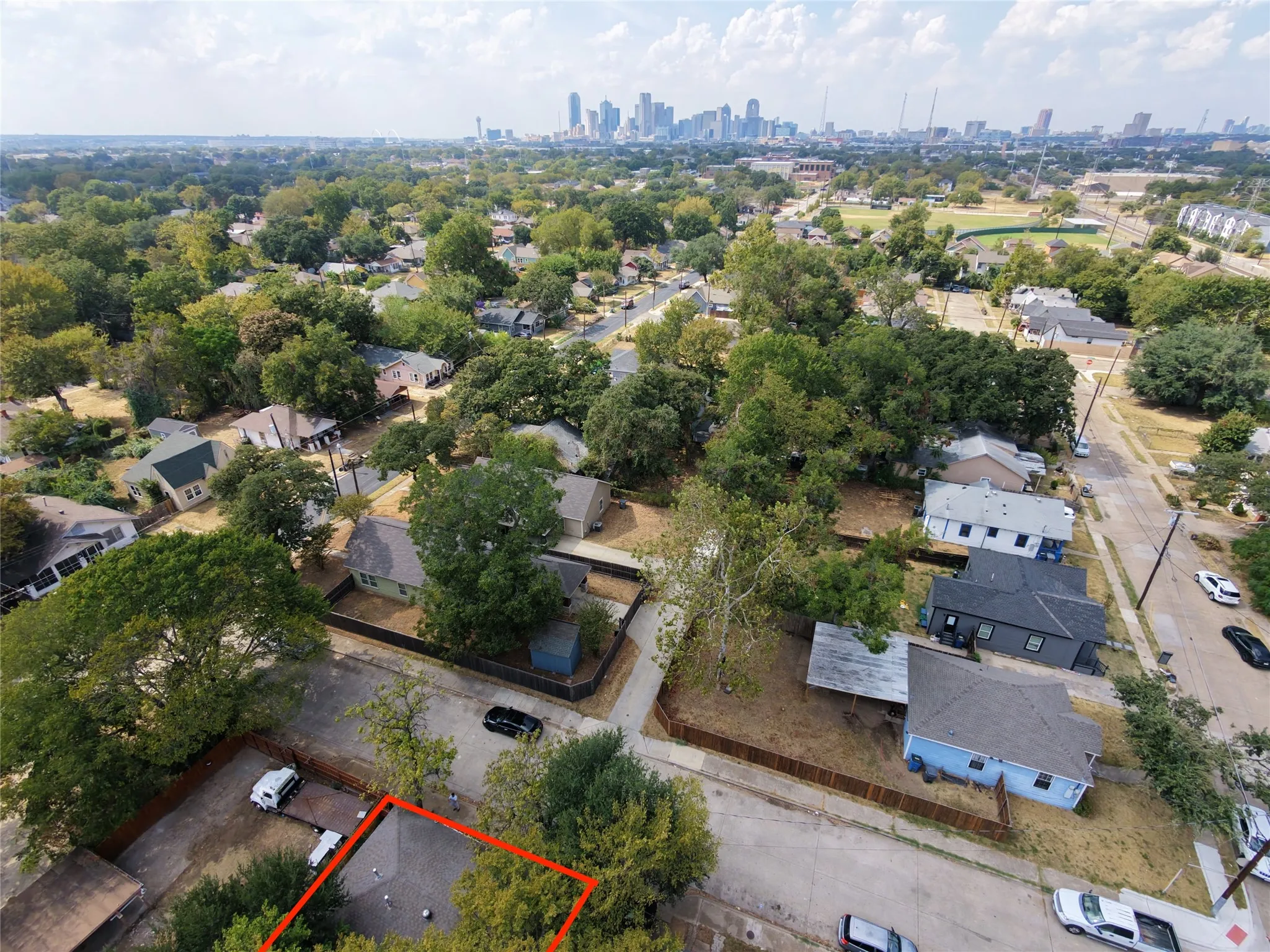 Aerial perspective of a residential area with a prominent city skyline in the distance