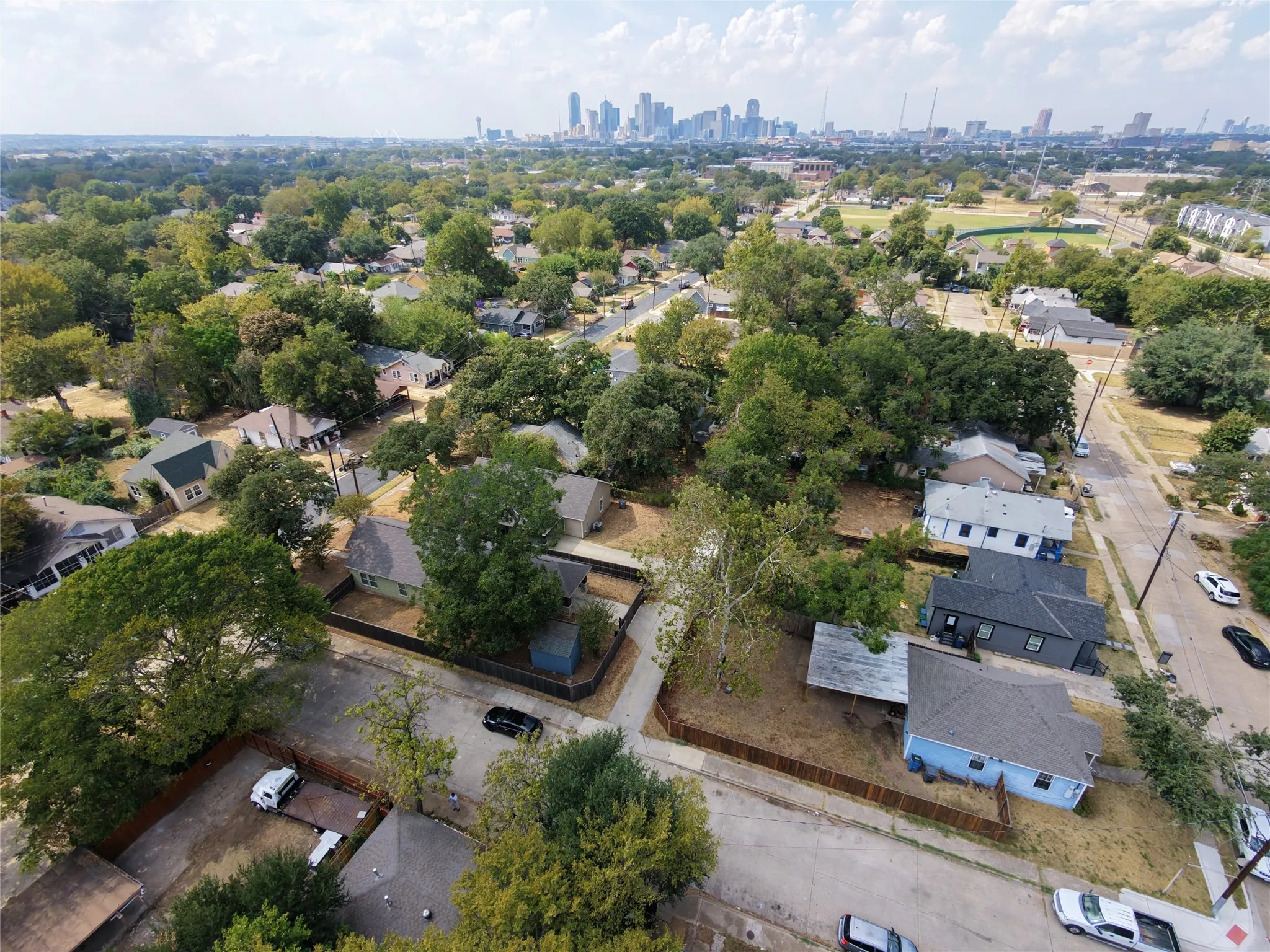 Aerial perspective of a residential area with a prominent city skyline in the distance