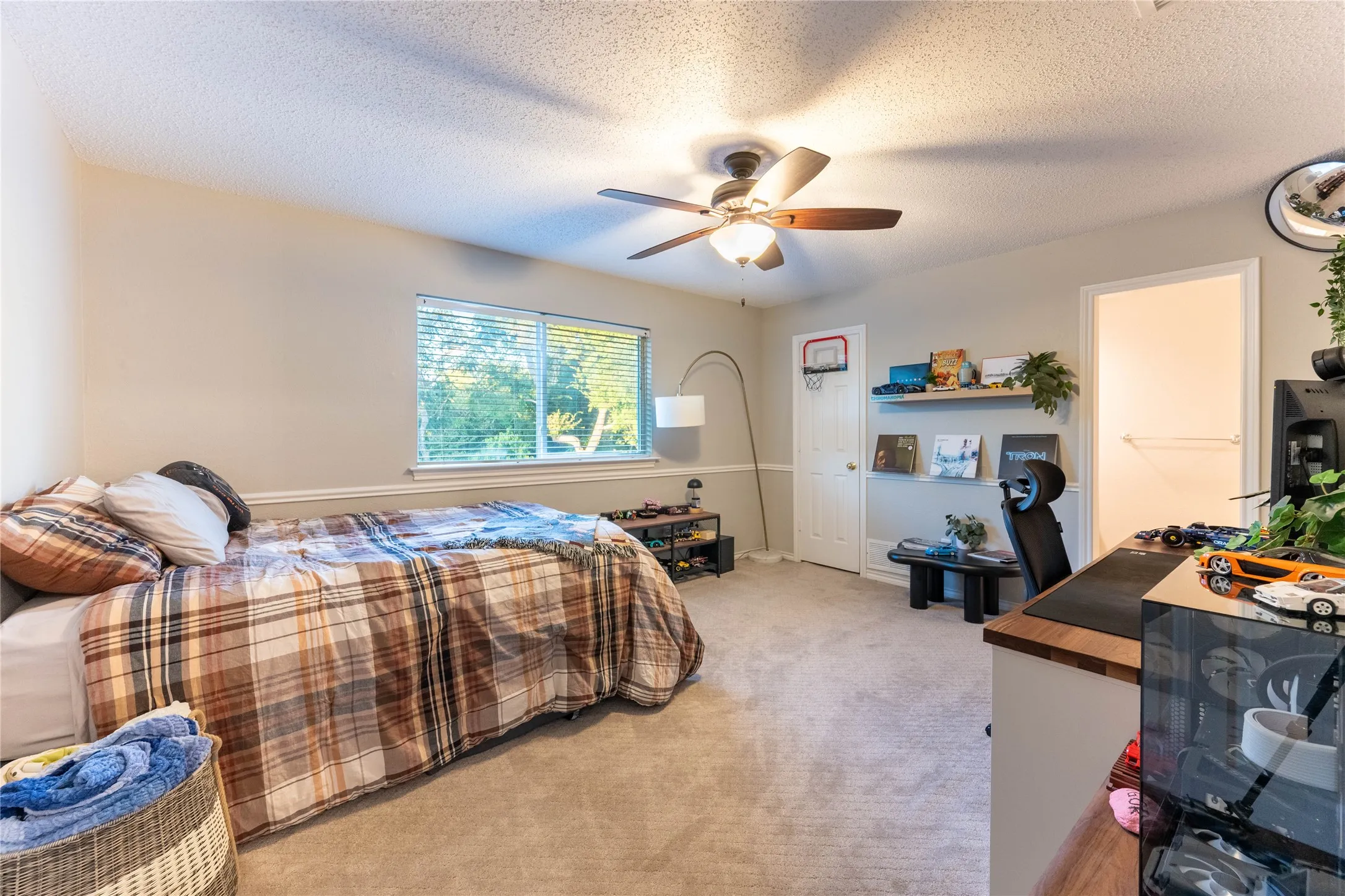 Wall-to-wall carpeting, window with blinds, ceiling fan with integrated lighting, built-in wall shelf, and crown molding