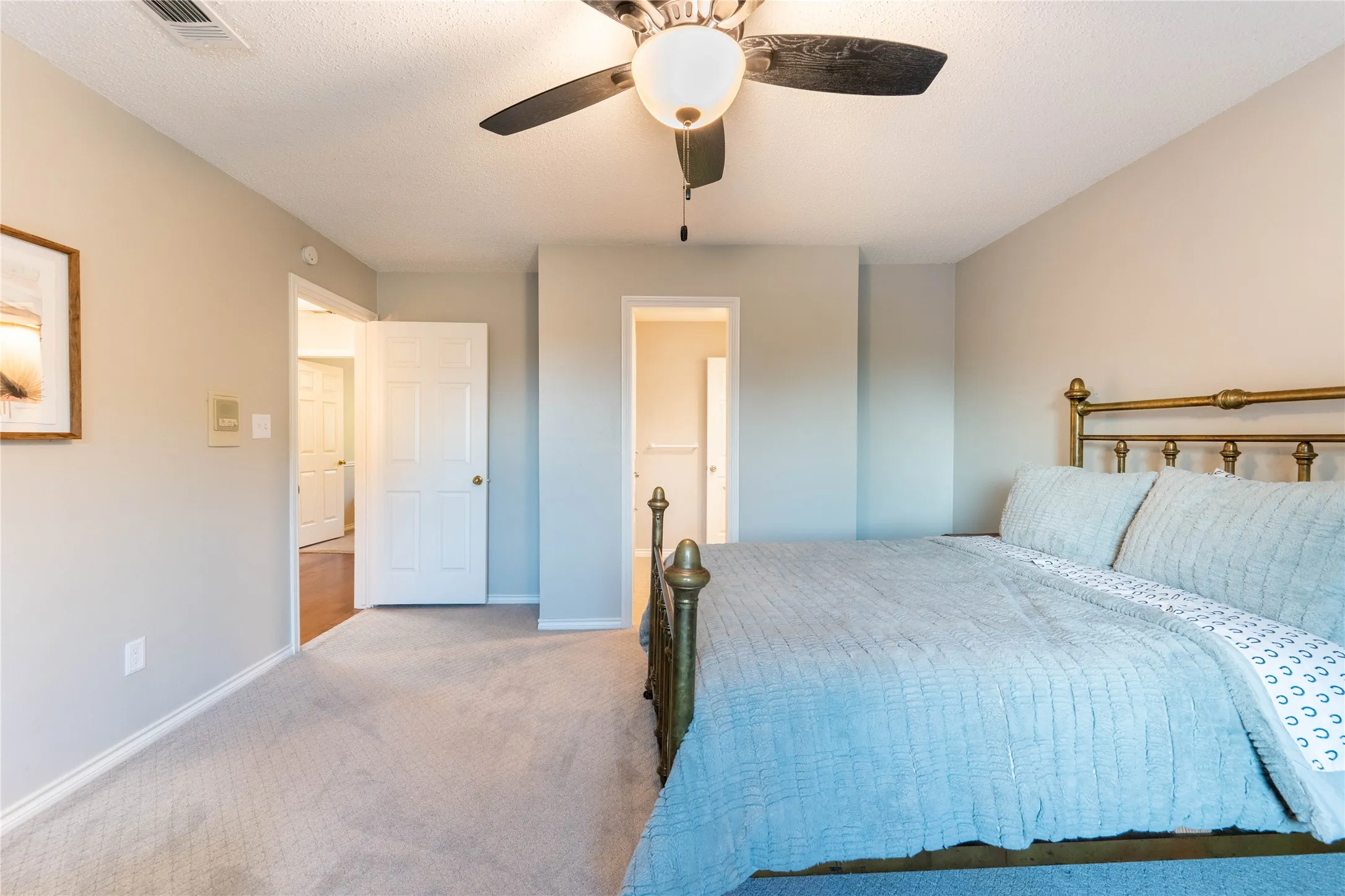 Neutral wall paint, ceiling fan, white trim, and light-toned carpeting