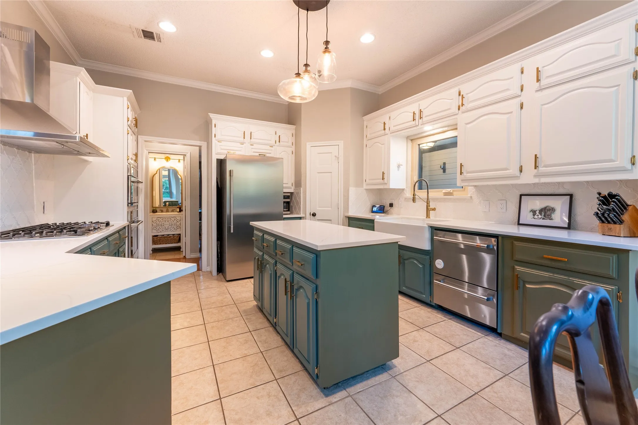 Kitchen featuring a center island, white countertops, tile flooring, stainless steel appliances, and a farmhouse sink