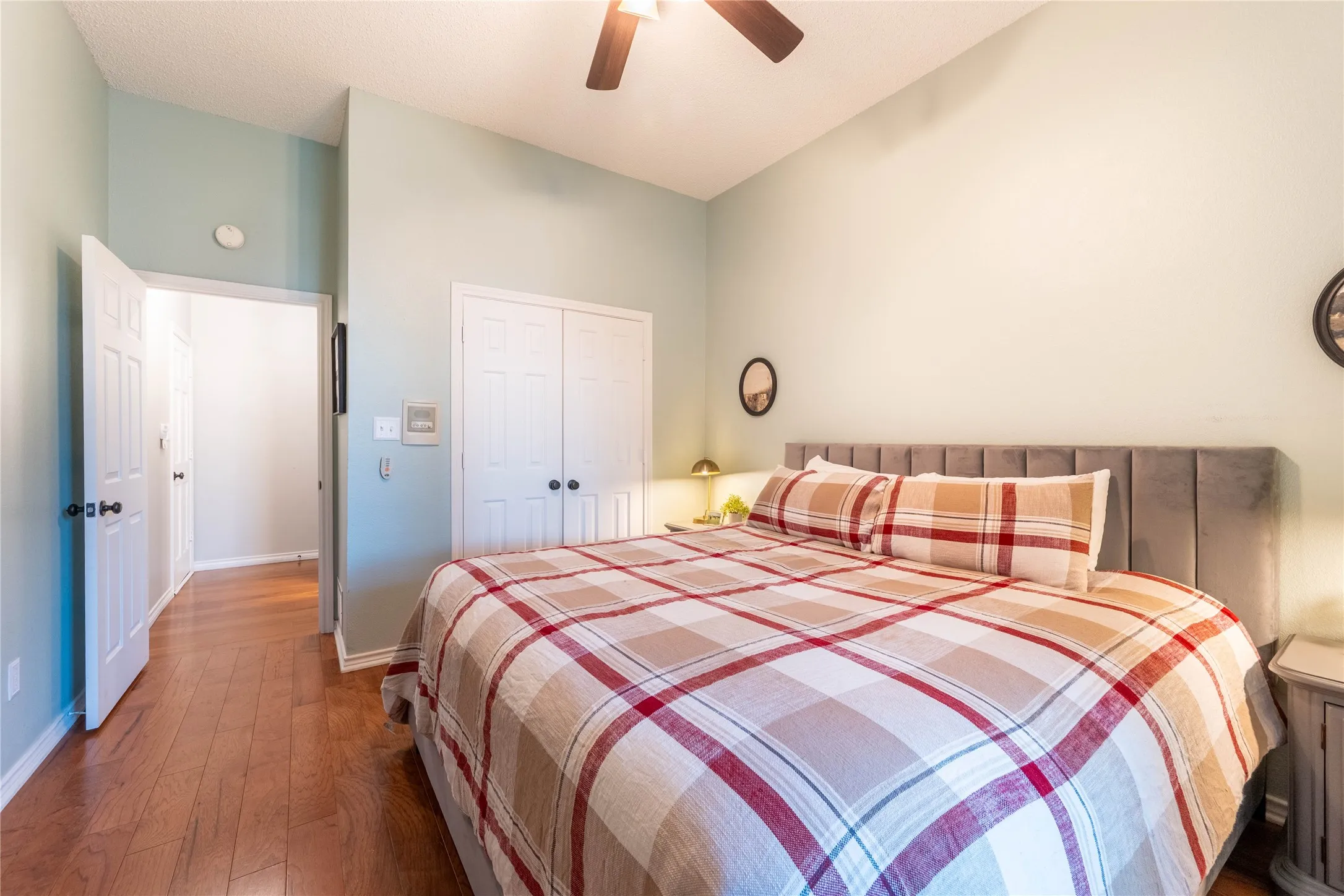 Wood-finish flooring, vaulted ceiling, and a ceiling fan