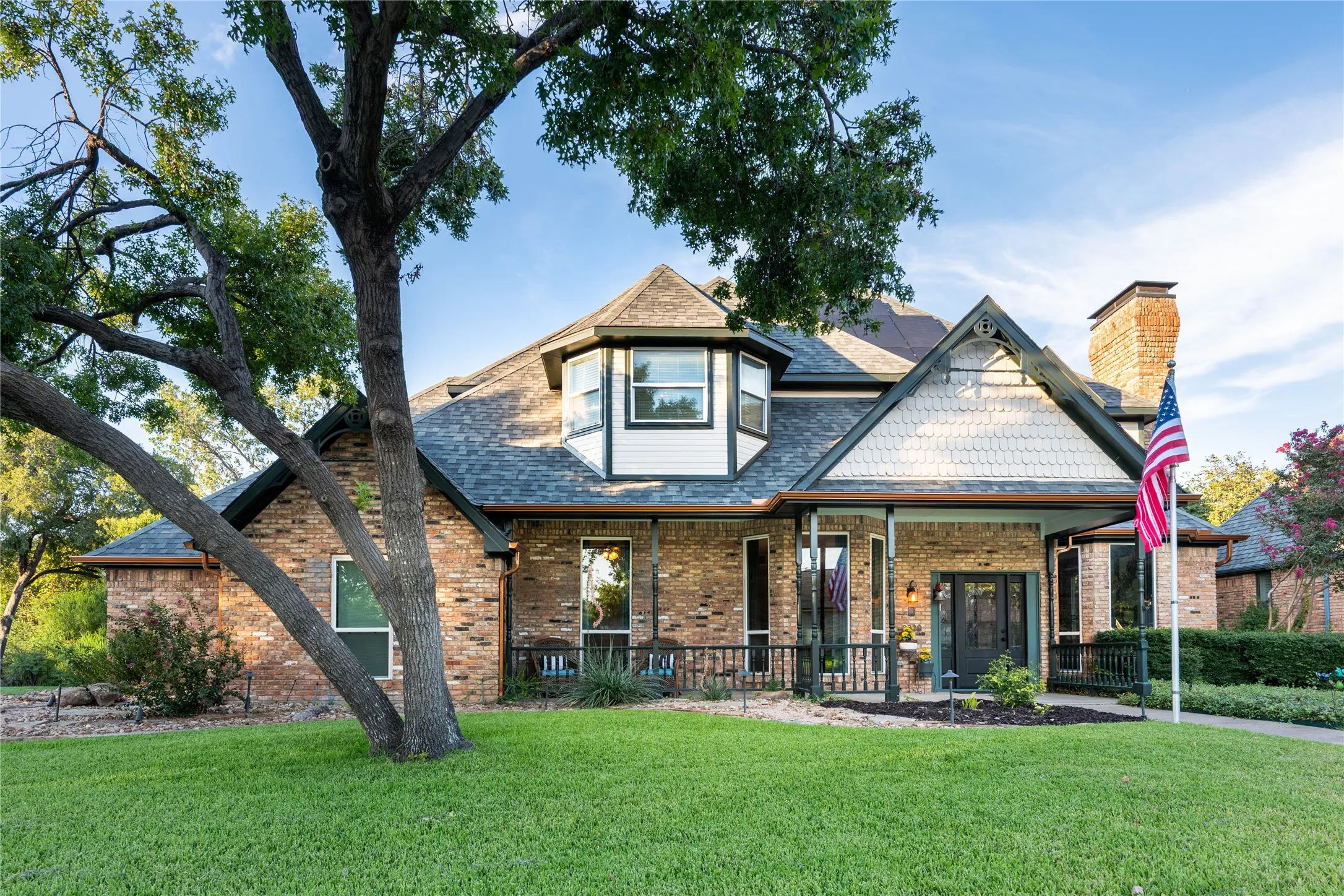 Brick exterior with shingle accents and a covered front porch