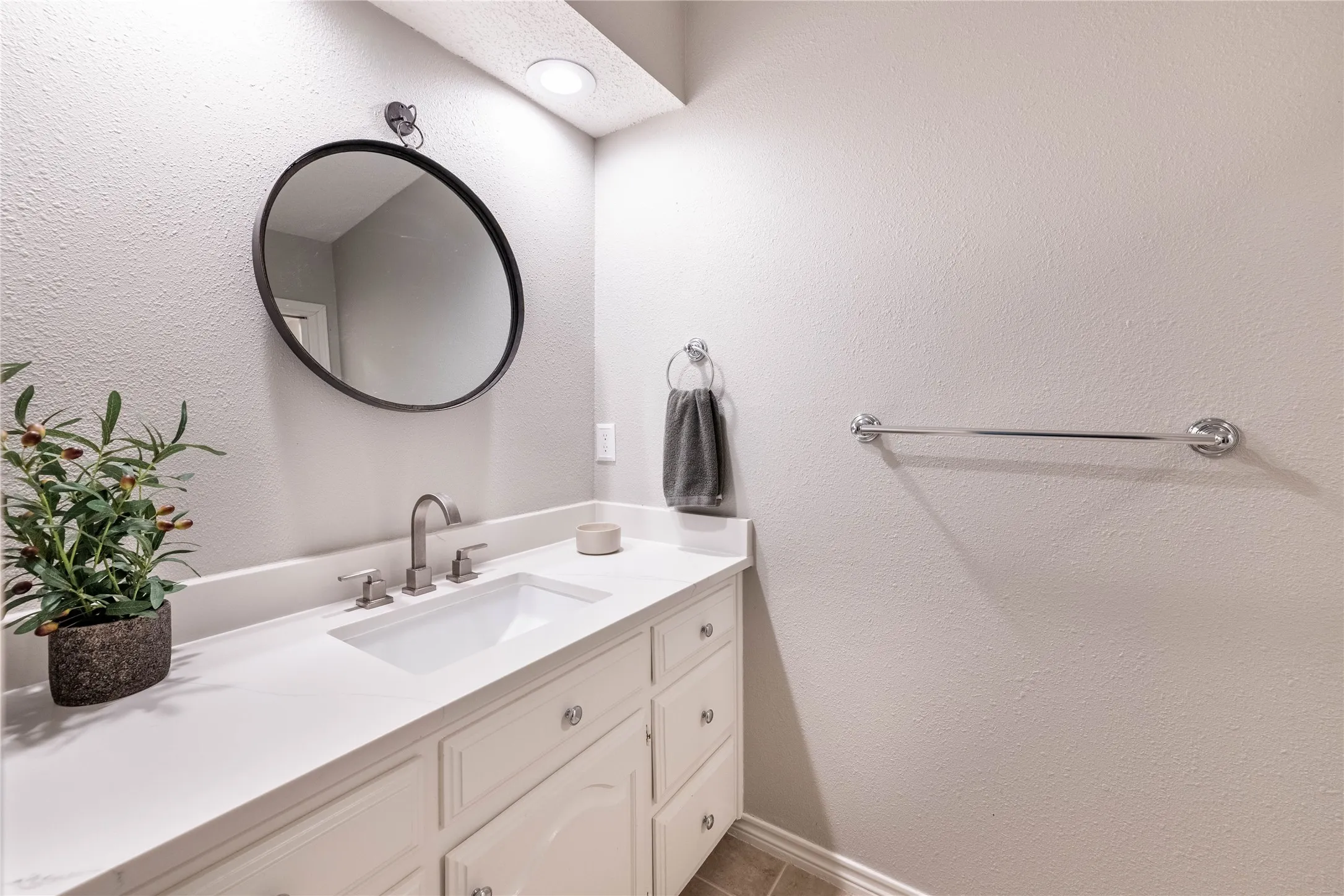 White vanity with ample storage, integrated sink, and brushed nickel fixtures