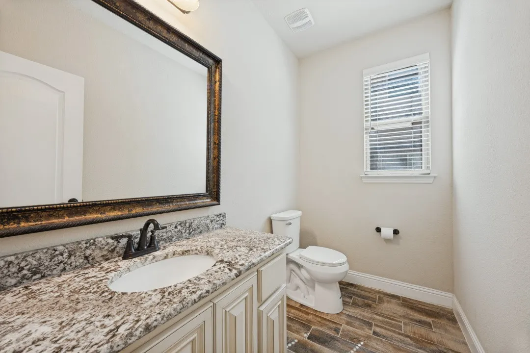 Vanity with granite countertop, integrated sink, and dark bronze faucet