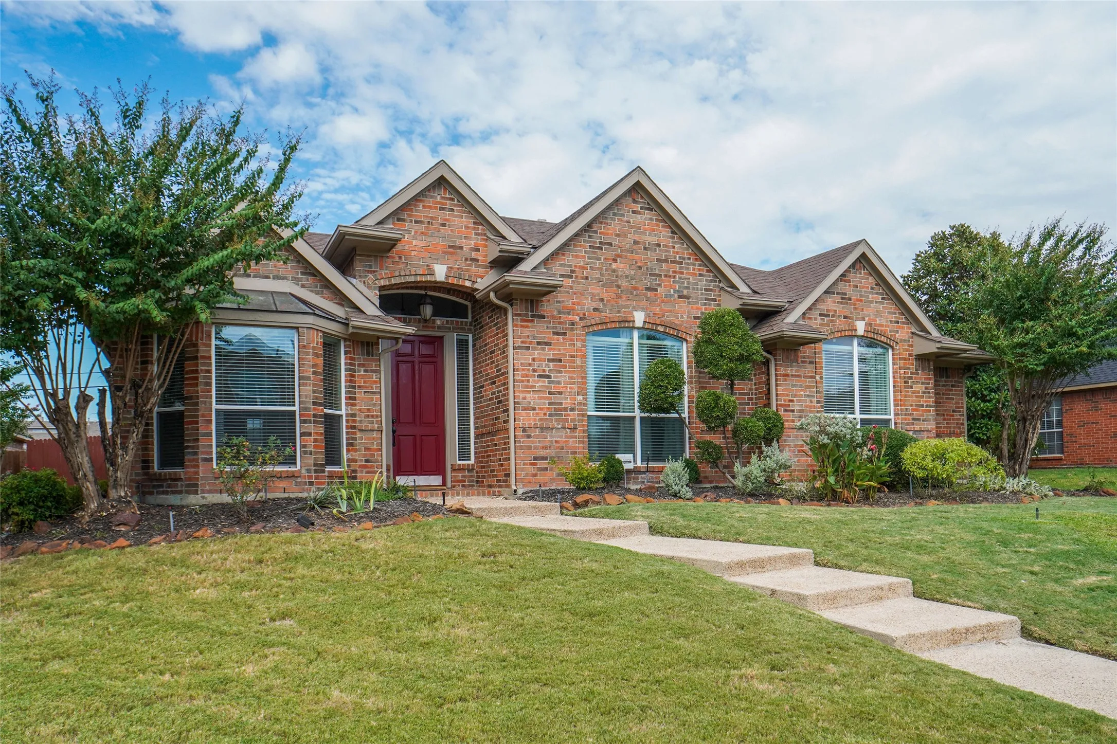 View of front of home featuring a front yard, brick siding, and a shingled roof