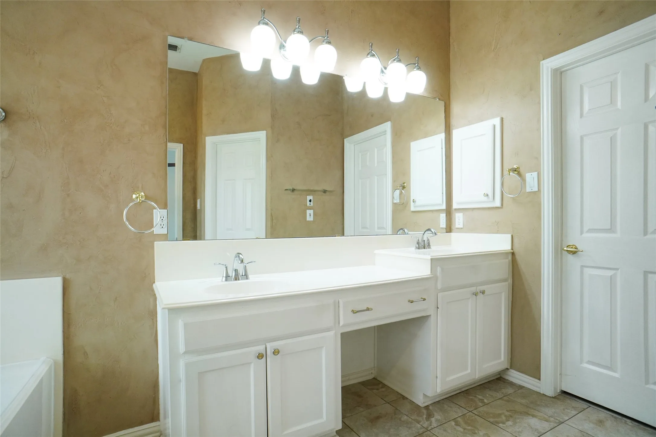 Bathroom featuring double vanity and light tile patterned floors