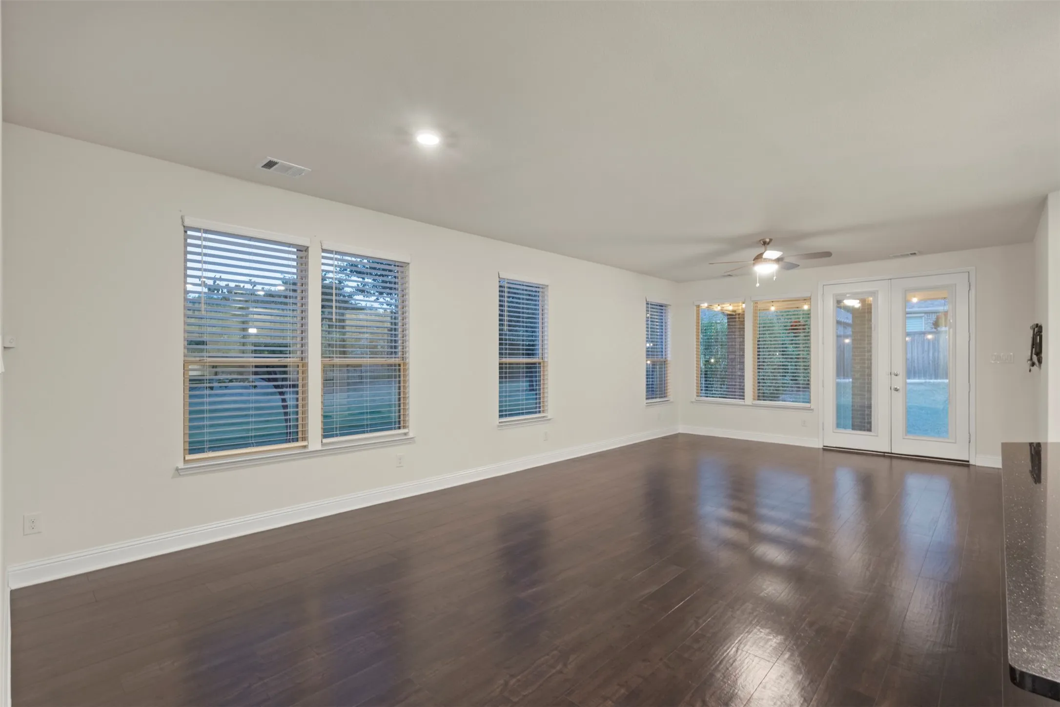 Dark wood-finish flooring, recessed lighting, and white walls